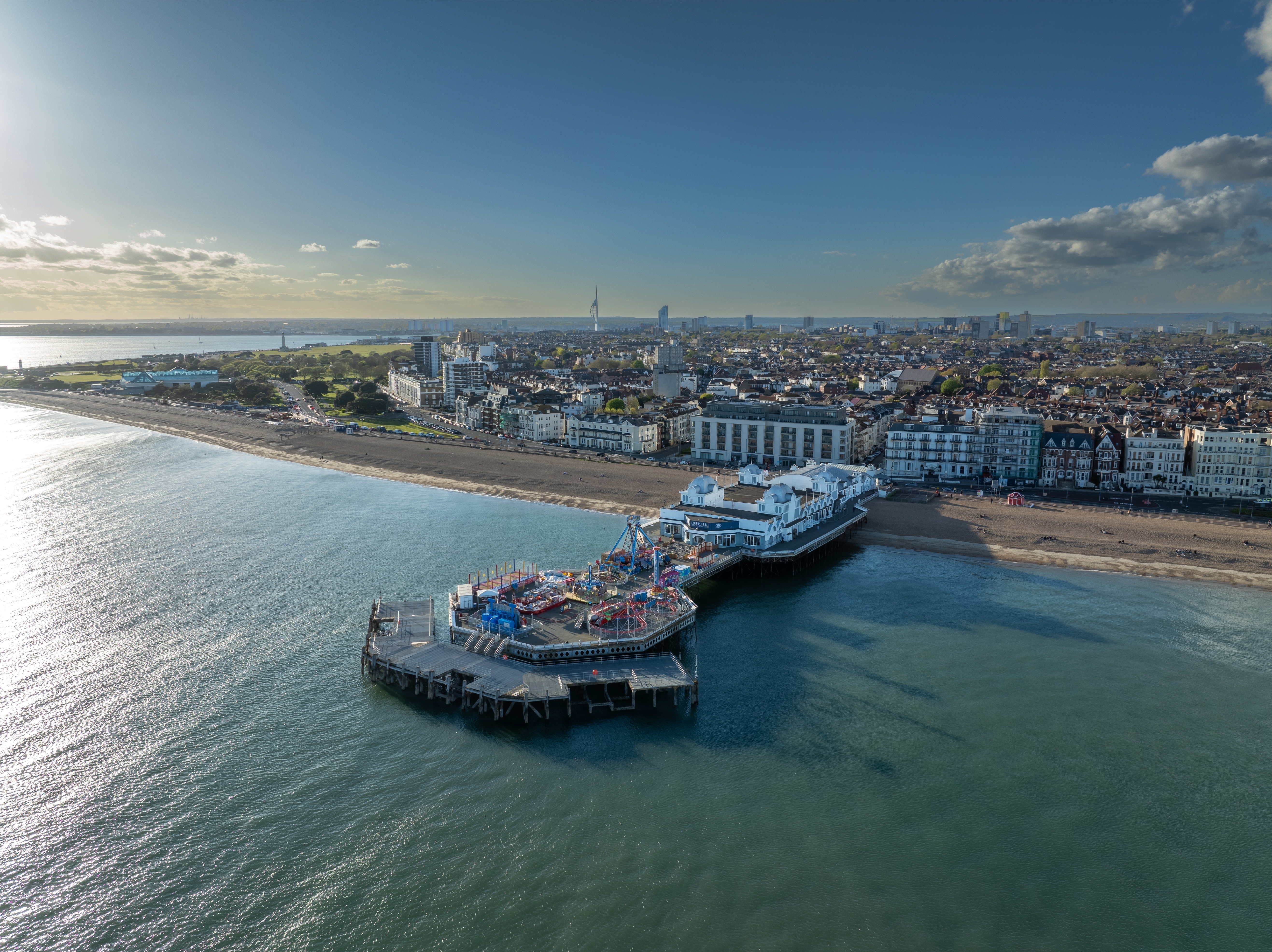 Luftfoto af den historiske Southsea Pier i Portsmouth med farverige forlystelser og blåt hav