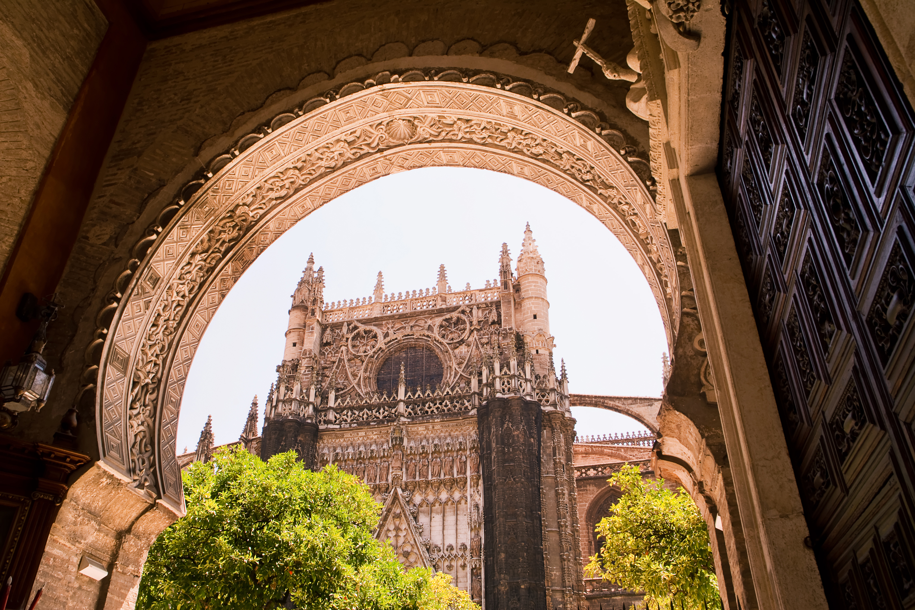Spaniens berømte Sevilla katedral med gotisk arkitektur set gennem maurisk buepan
