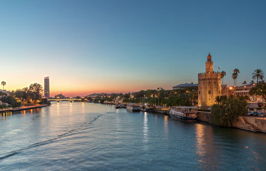 Spaniens Sevilla med middelalderligt Torre del Oro tårn ved floden i solnedgang