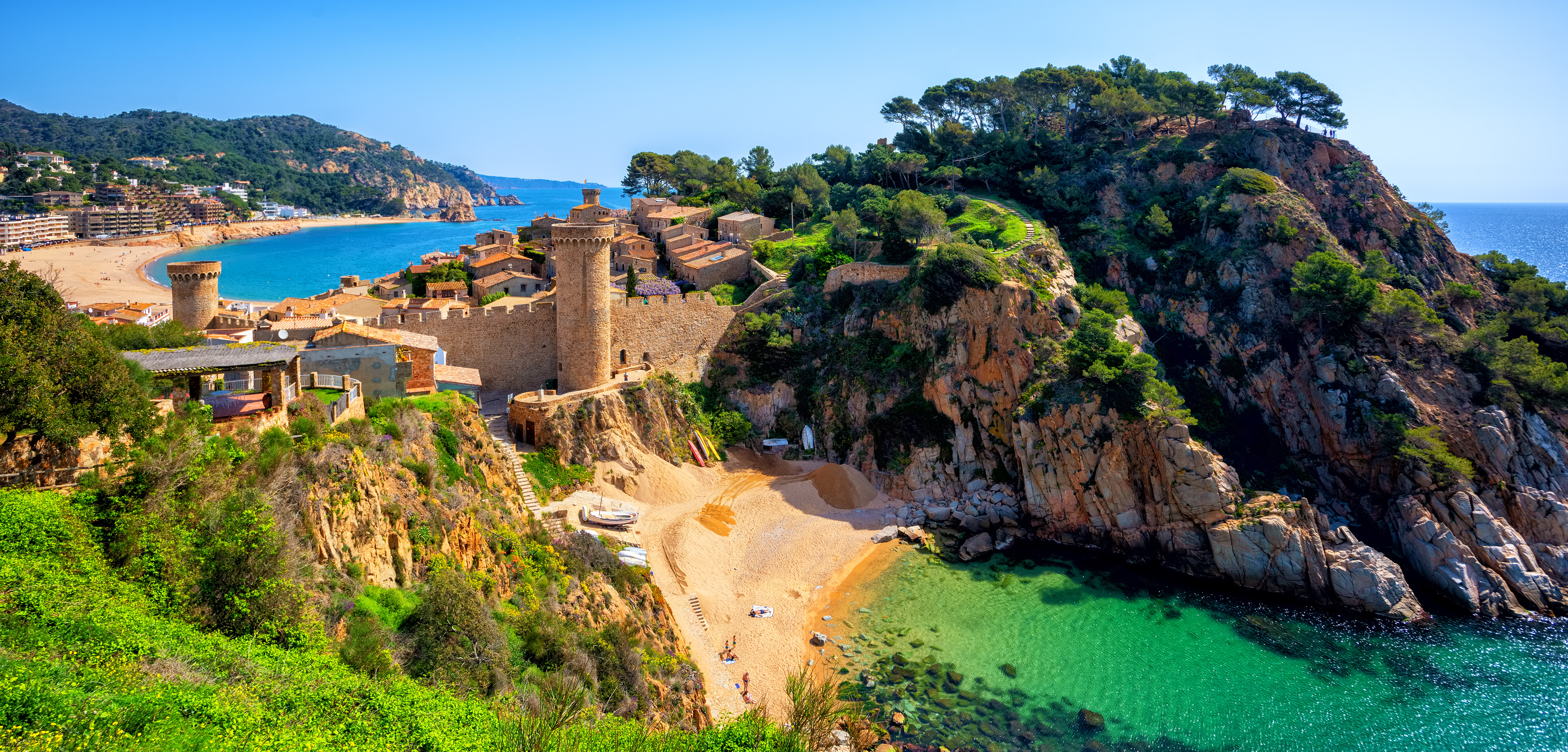 Tossa de Mar middelalderslot paa klipper med fantastisk udsigt over azurblaa Middelhavsbugt og badestrand