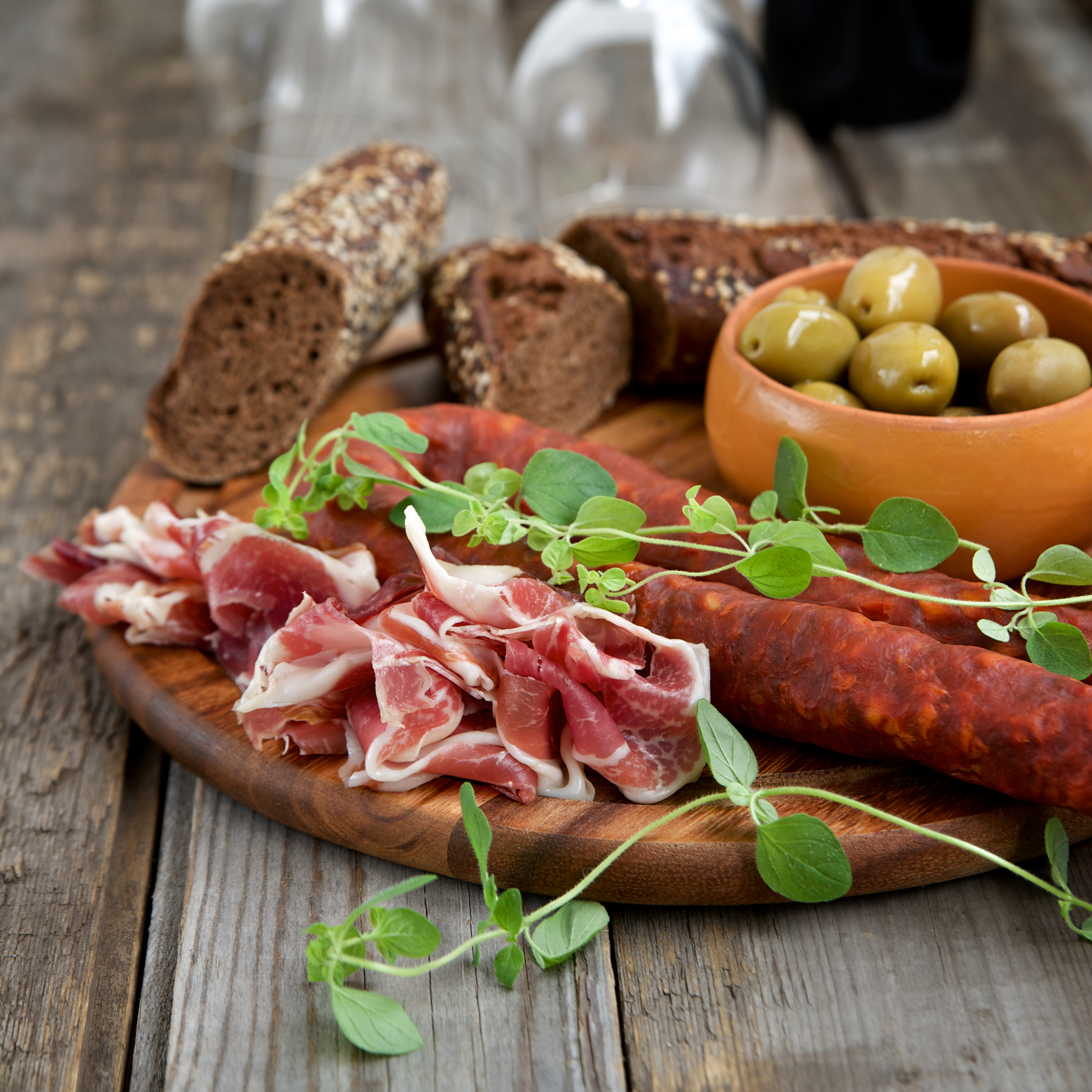 Spansk charcuteri bræt med salami, prosciutto og grønne oliver - traditionel spansk appetizer