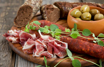 Spansk charcuteri bræt med salami, prosciutto og grønne oliver - traditionel spansk appetizer
