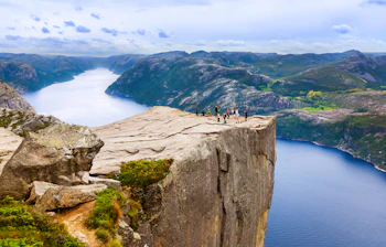 Turister nyder den berømte udsigt fra Preikestolen klippen i Norge
