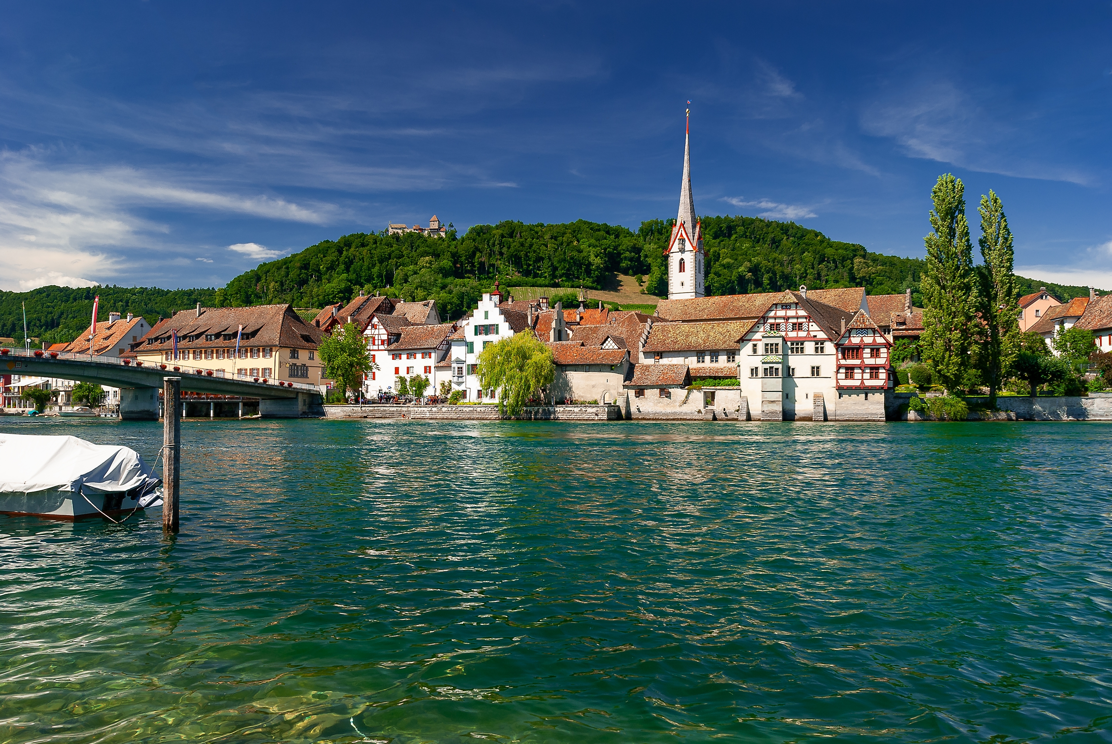 Naturskøn udsigt over Stein am Rhein med den historiske bykerne spejlet i det grønne Rhinen i Schweiz en sommerdag