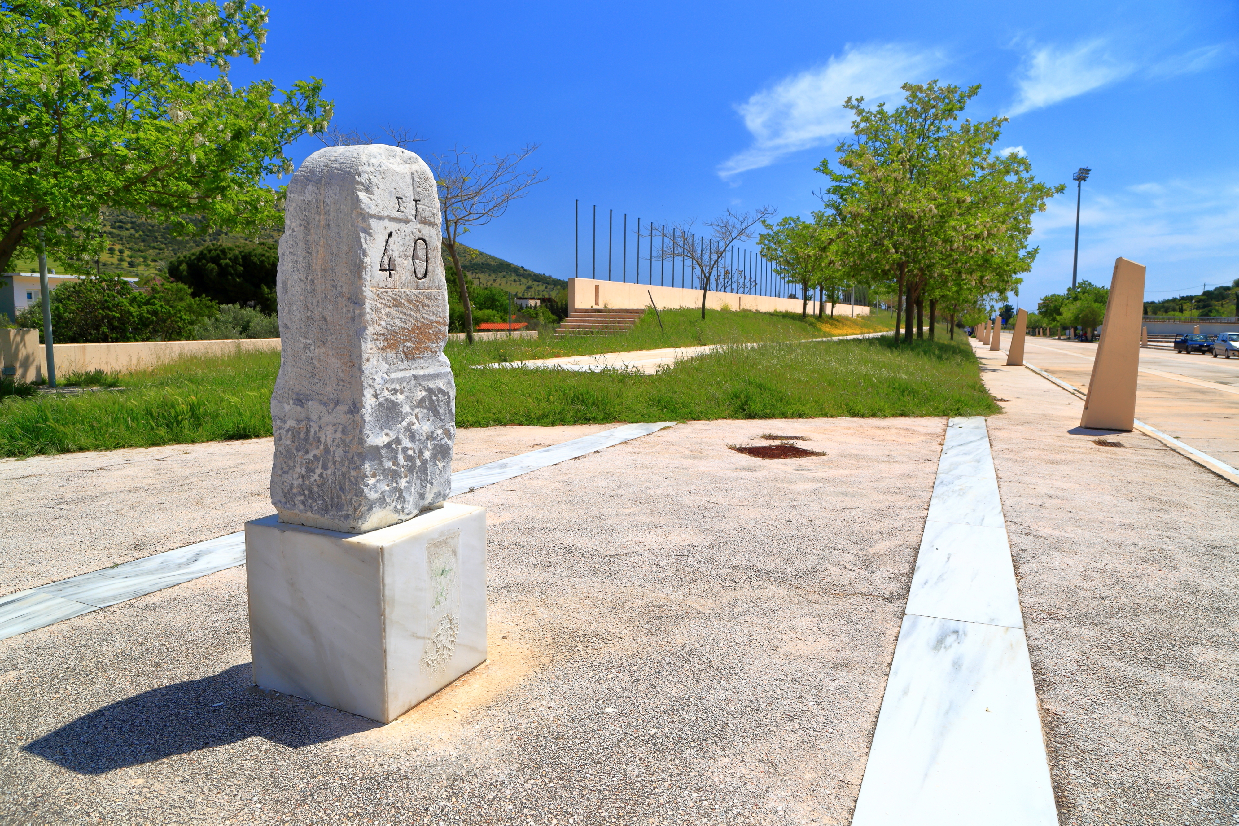 Historisk stenmonument med distancemarkering i sydeuropæisk parkområde