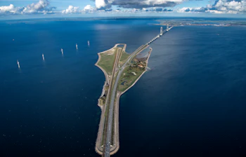 Luftfoto af Storebæltsbroen med Sprogø og havvindmøller, der viser den smukke danske kystlinje og det blå hav