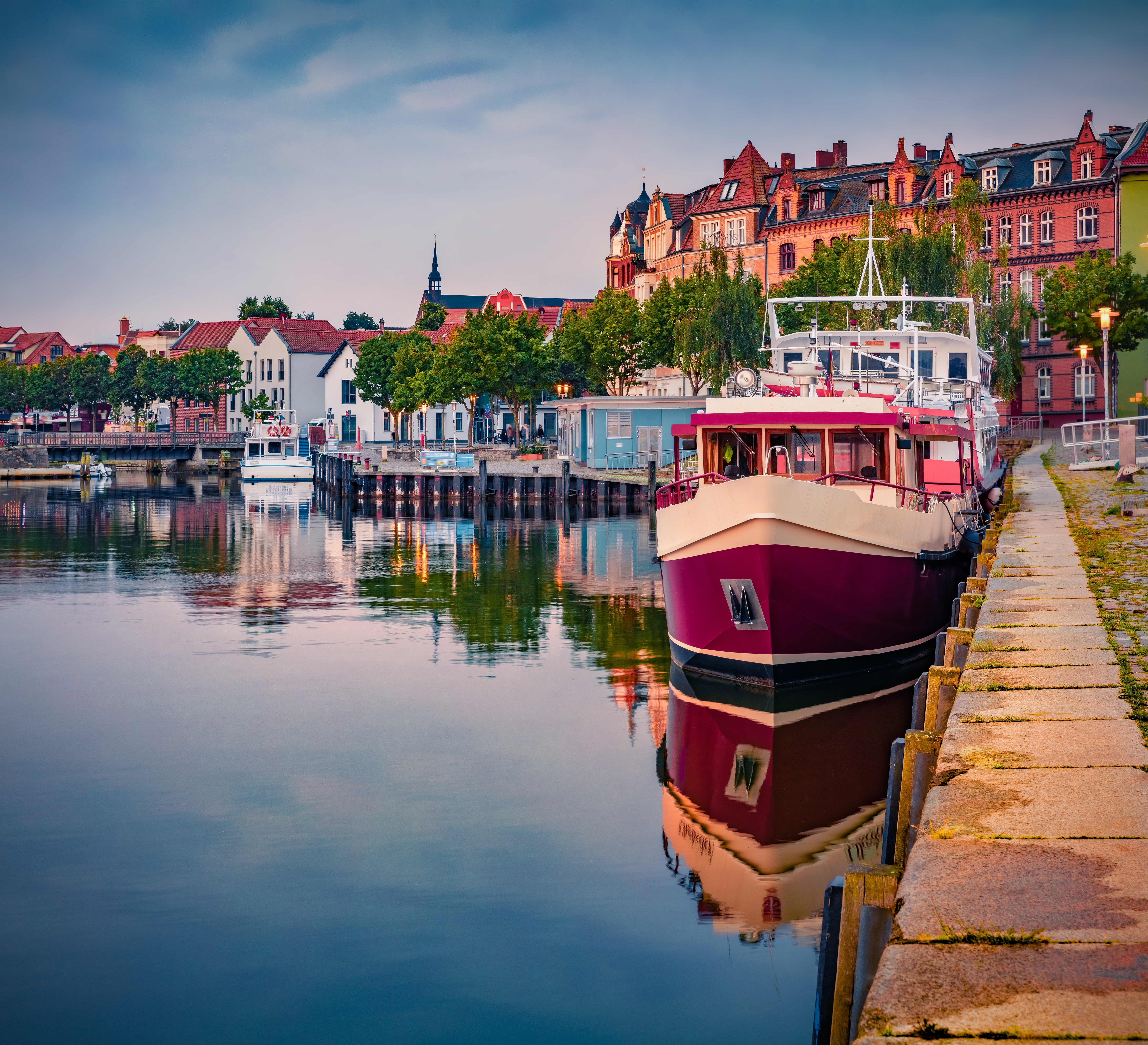 Fredfyldt morgengry over Stralsund kystby i Tyskland med fiskerbåd og den smukke havnefront langs Østersøen