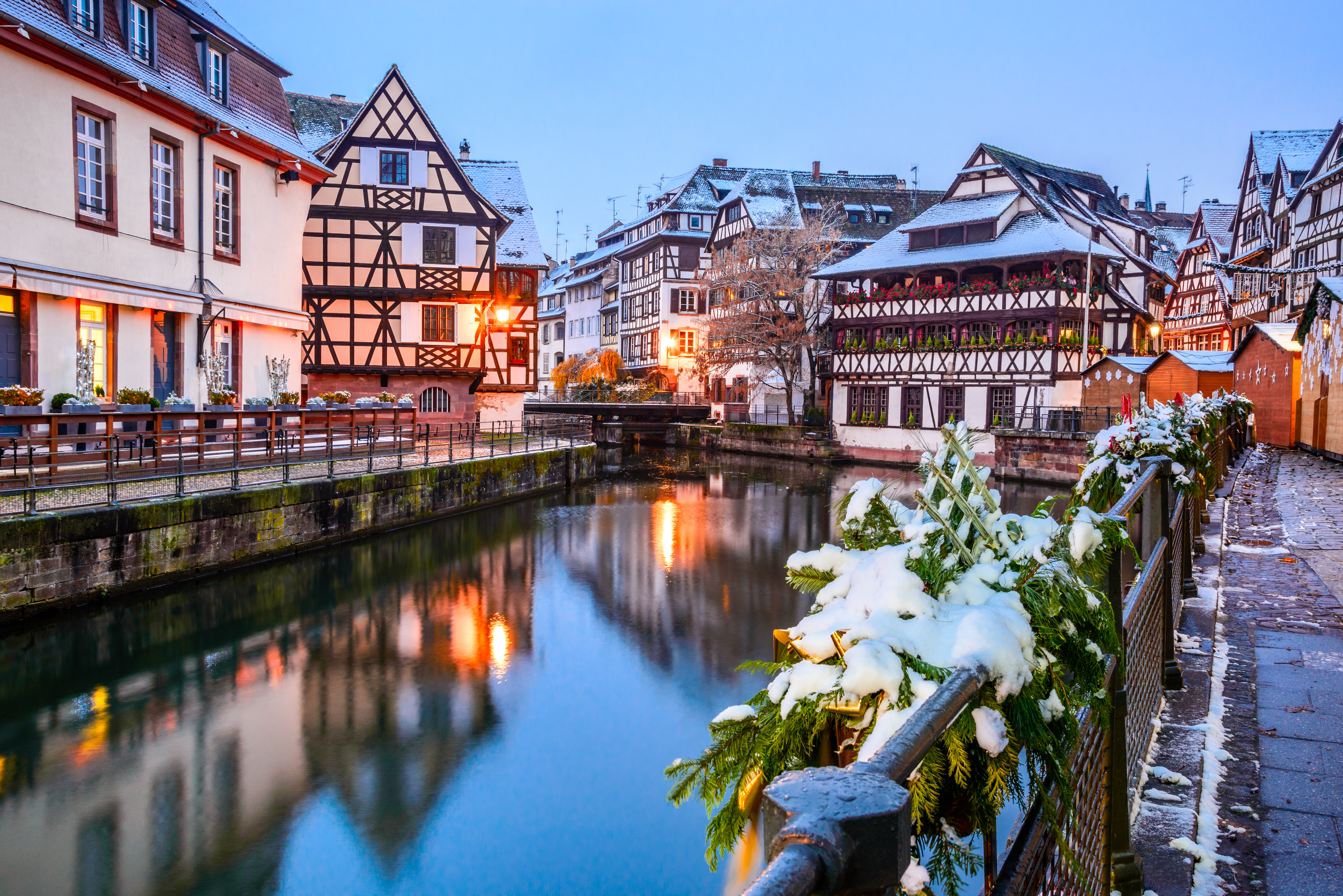 Farverige alsaciske bindingsværkshuse i snevejr ved floden i Strasbourg centrum