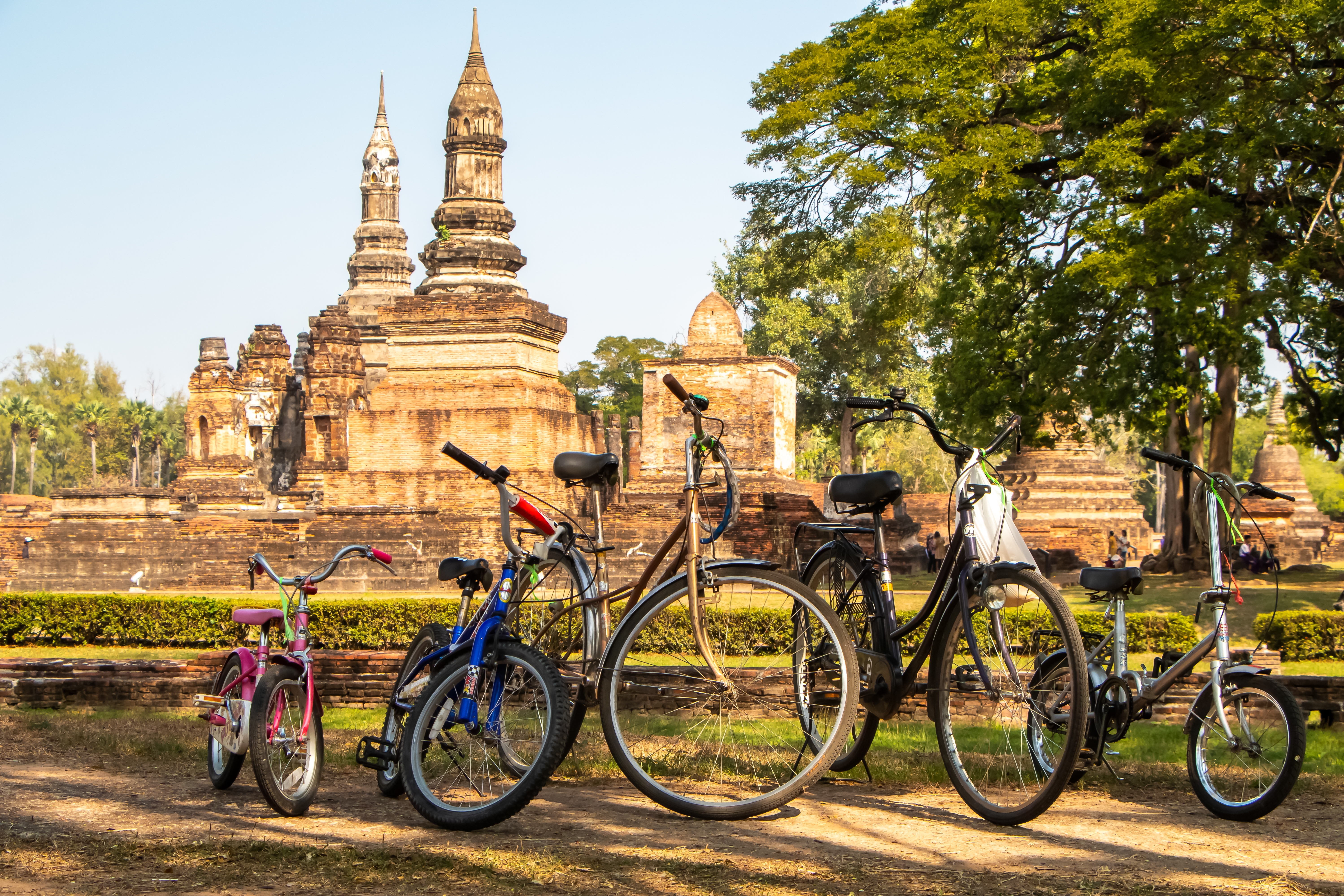 Cykler parkeret ved de ikoniske tempelruiner i Sukhothai Historical Park, Thailand