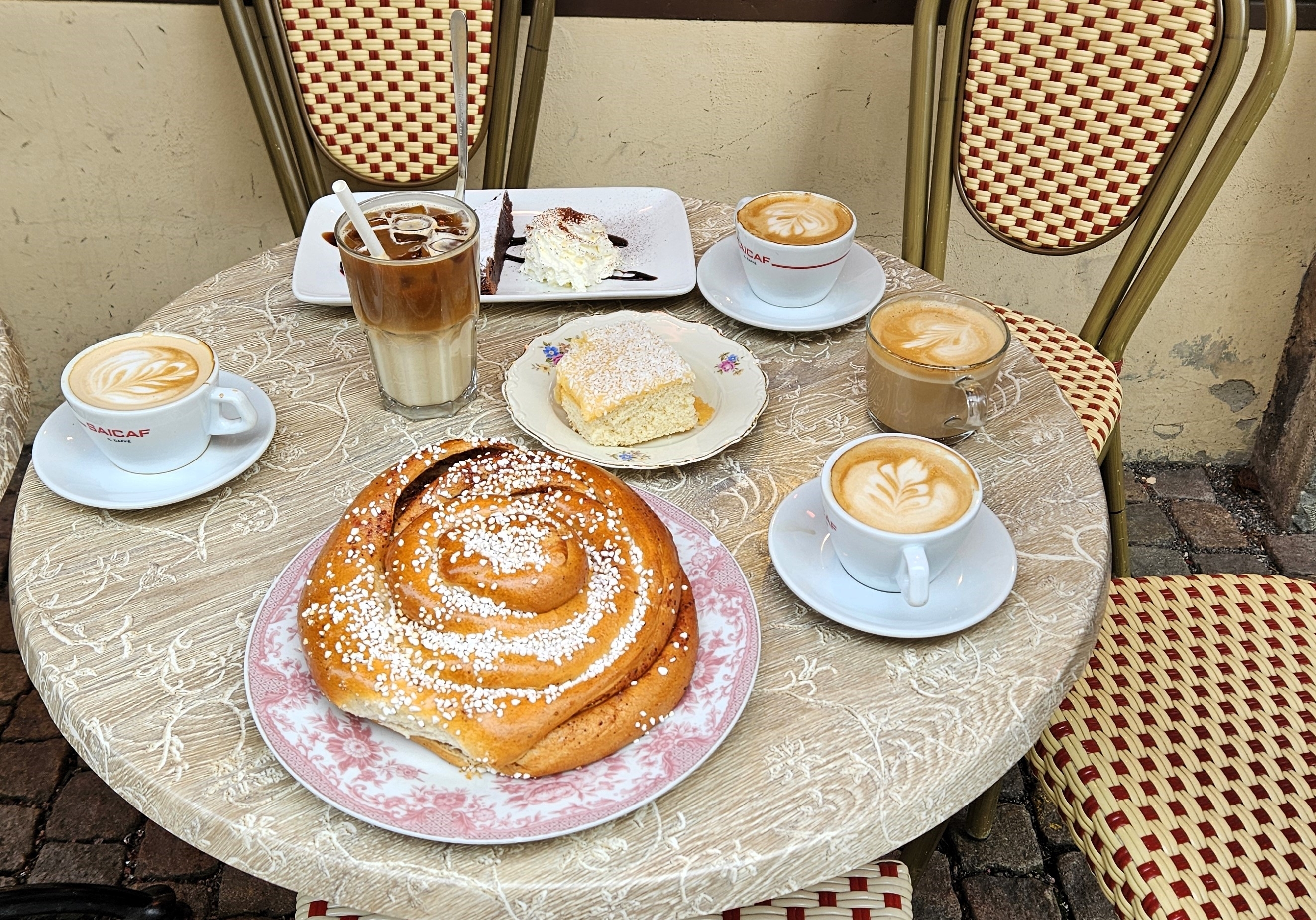 Nyd en klassisk svensk fika med stor kanelbolle, latte og kager på hyggelig udendørs café i Haga, Göteborg