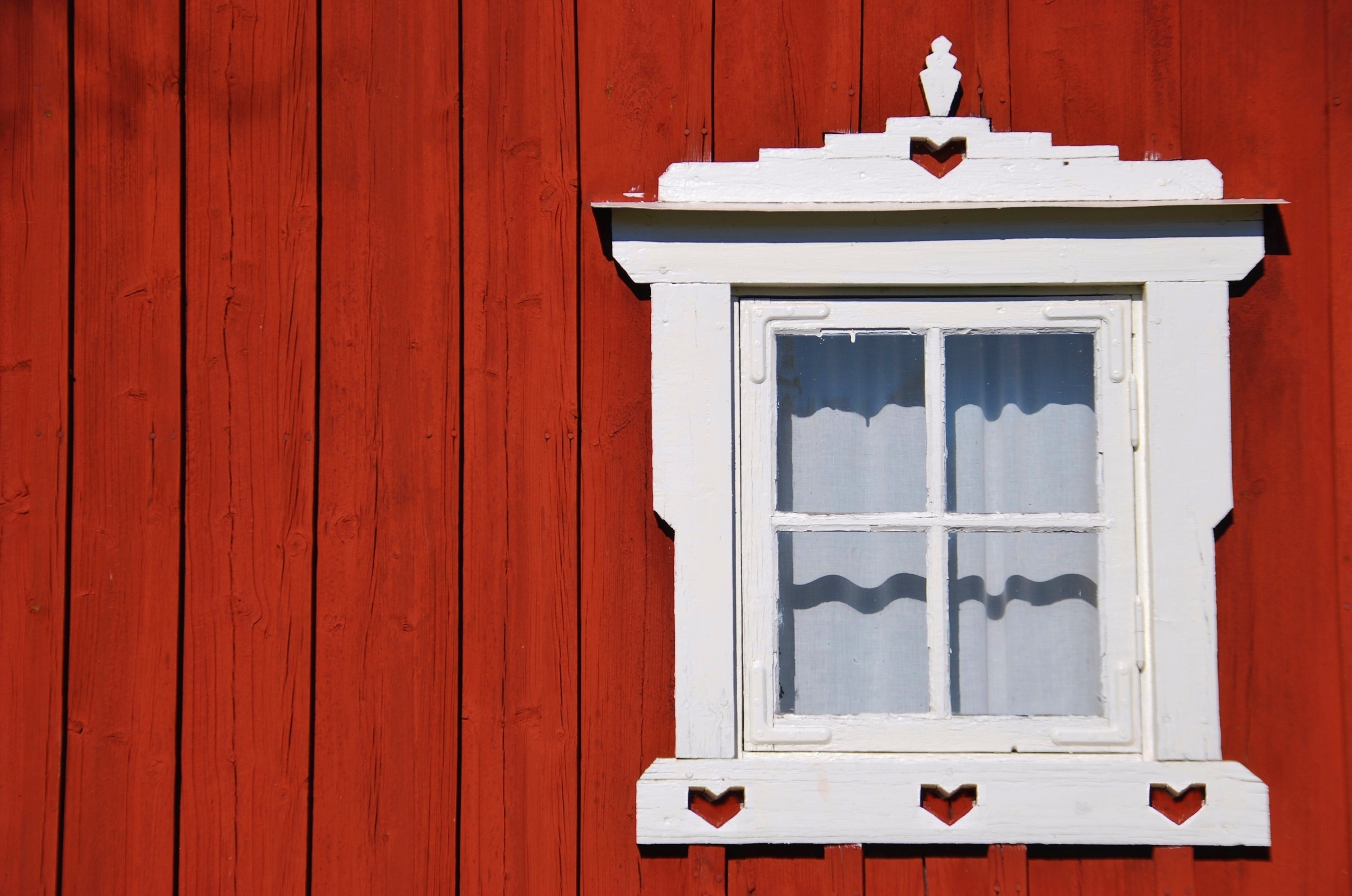 Svensk Falun rødt træhus med traditionelt hvidt vindue og hjertemotiver i Småland
