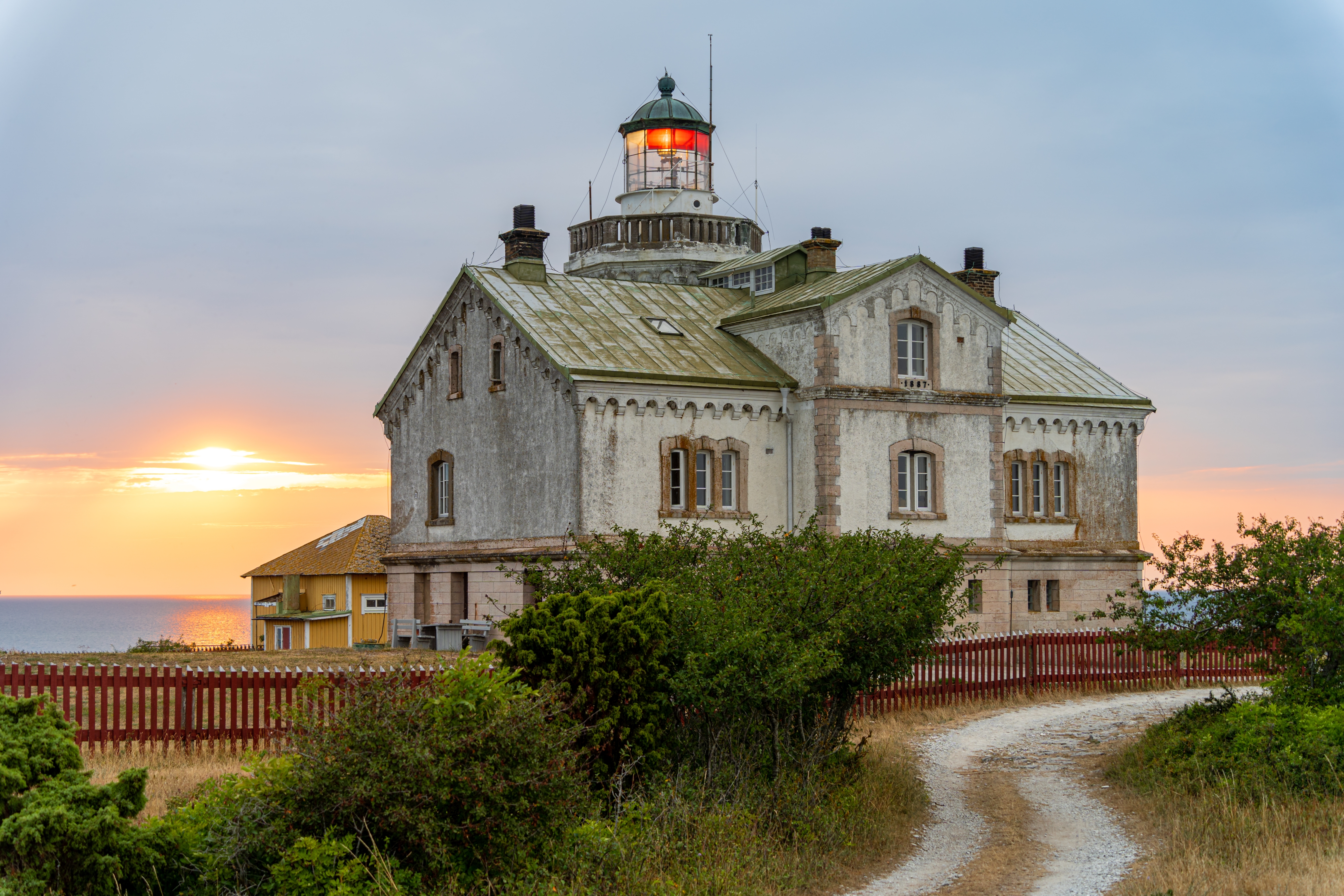 Klassisk svensk fyrtårn på Gotland ø med smuk kystlinje og aftenhimmel