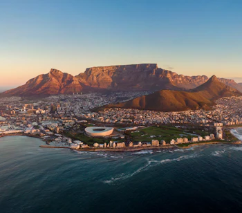 Majestætisk udsigt over Cape Town med det ikoniske Table Mountain og havet ved solnedgang, Sydafrika