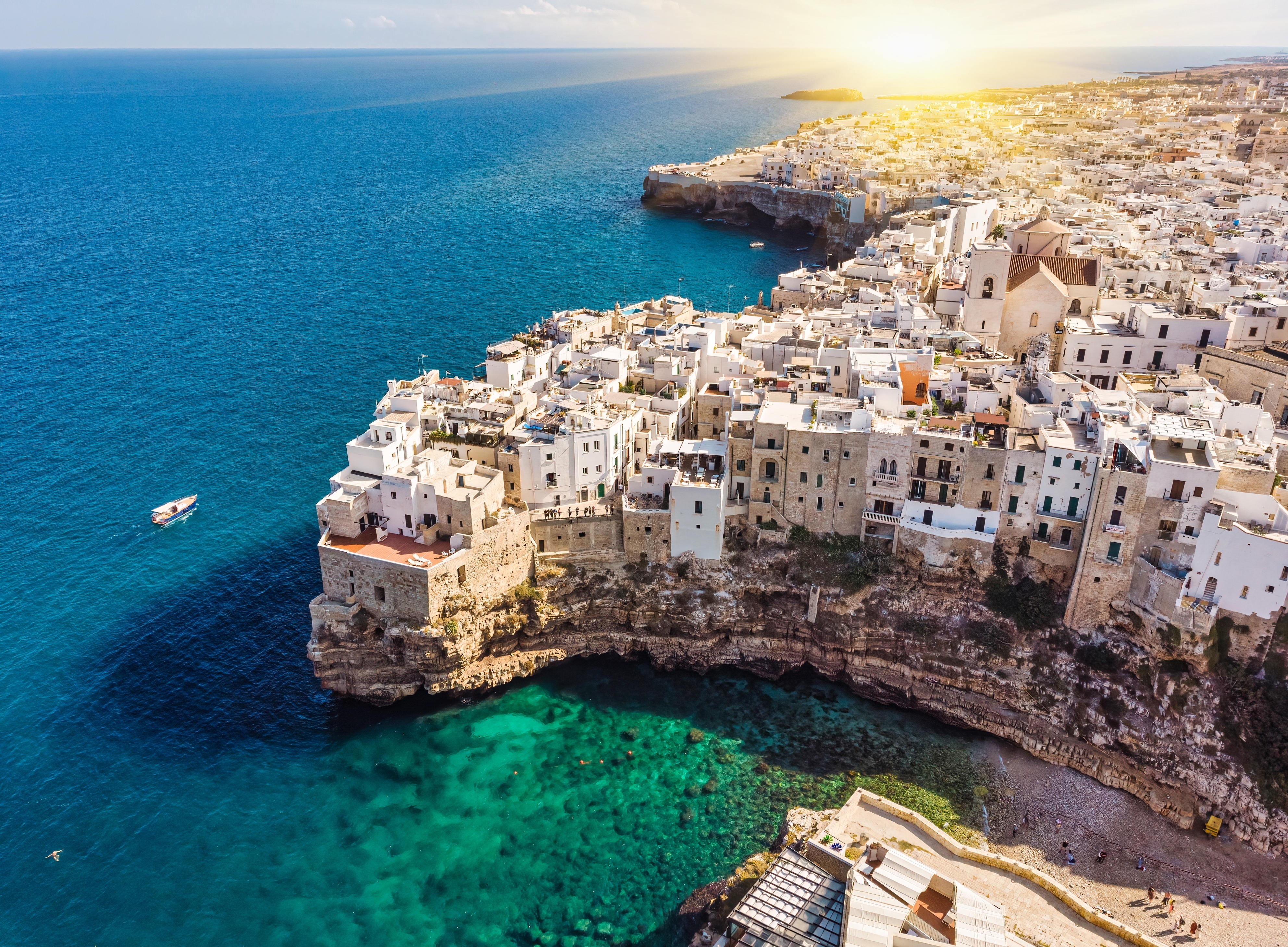 Polignano a Mare i Syditalien set fra luften med charmerende hvide bygninger og krystalklart middelhavsvand