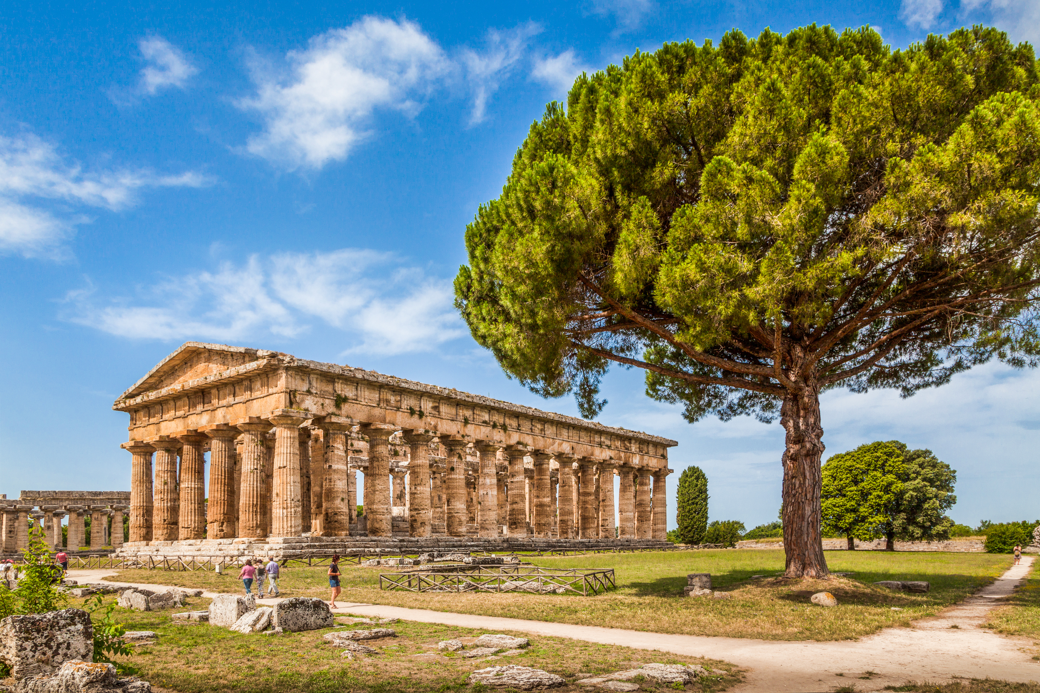 Majestætisk græsk tempel med doriske søjler i Paestum under italiensk blå himmel