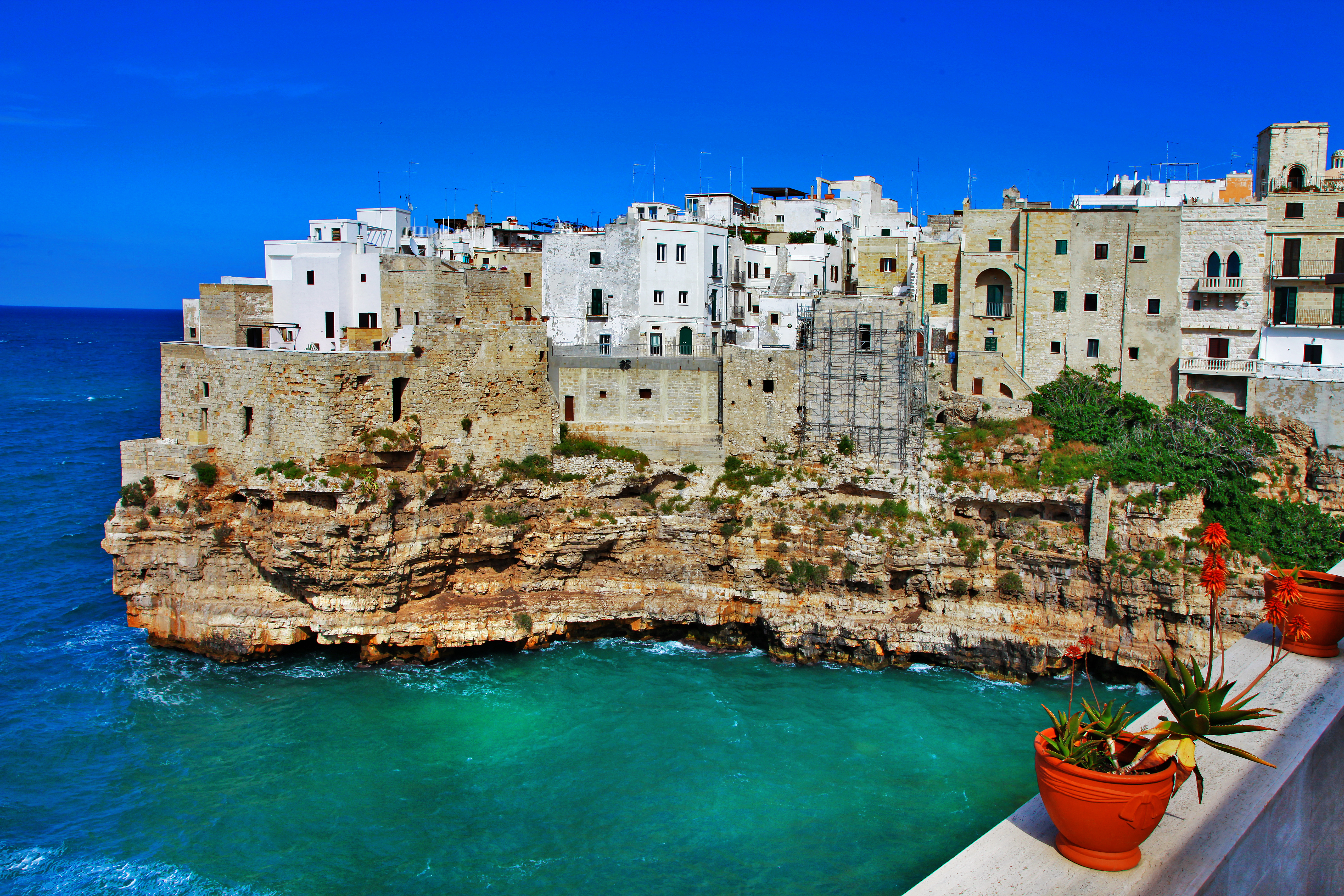 Ikonisk udsigt over Polignano a Mare i Syditalien med hvide bygninger på dramatiske klipper