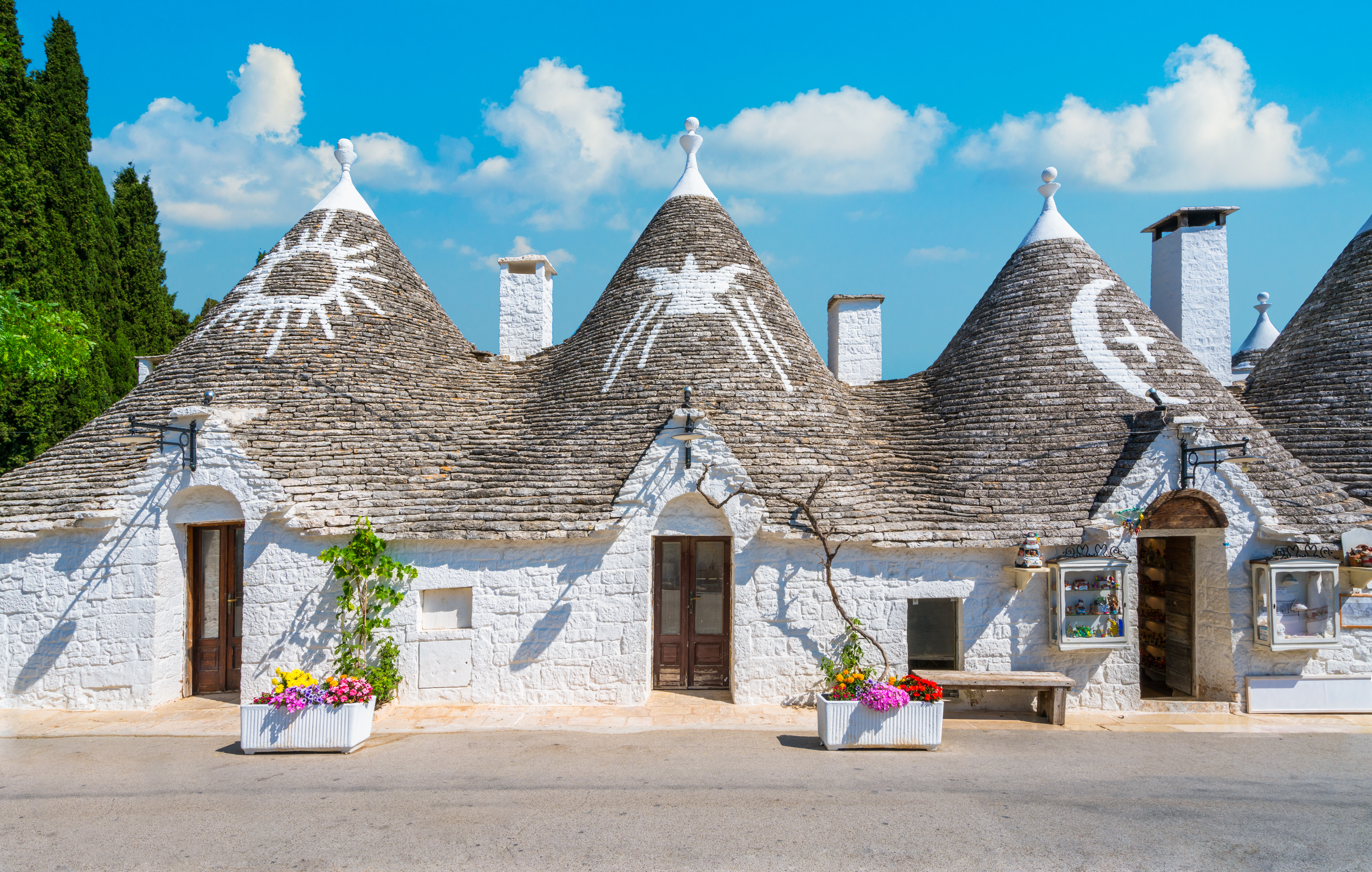 Unikke trulli boliger med stenlagt kegletag og blomster i Syditalien
