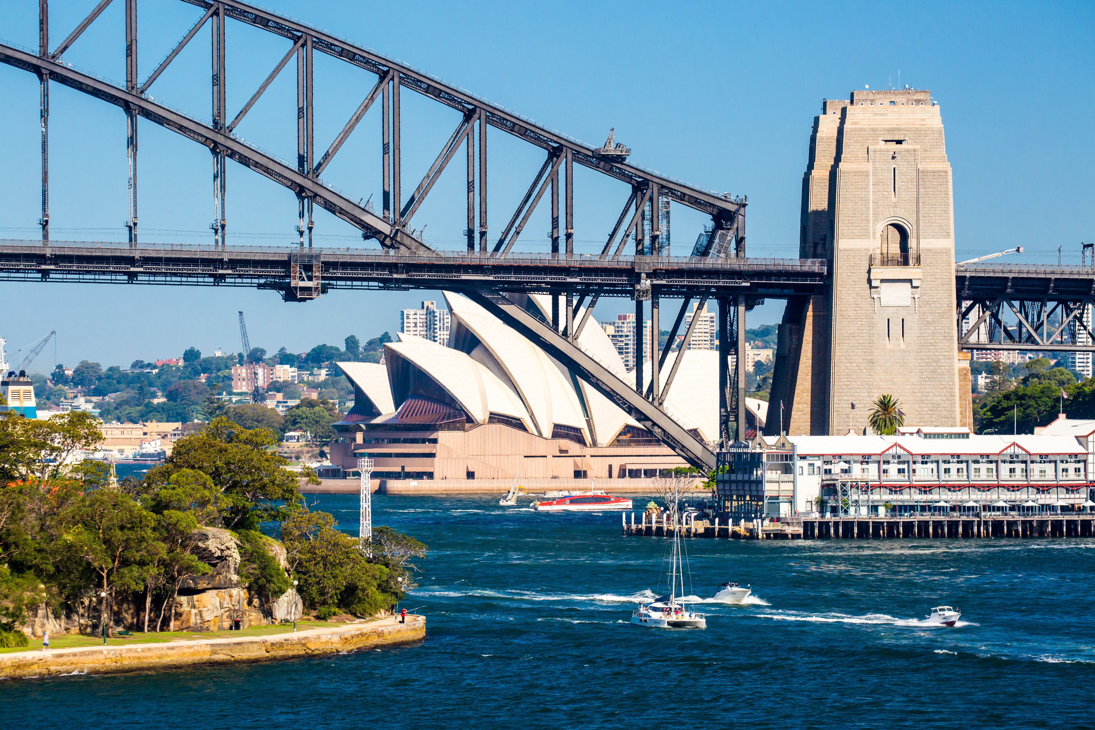 Postkortudsigt over Sydney Harbour med operahus og bro på dejlig dag