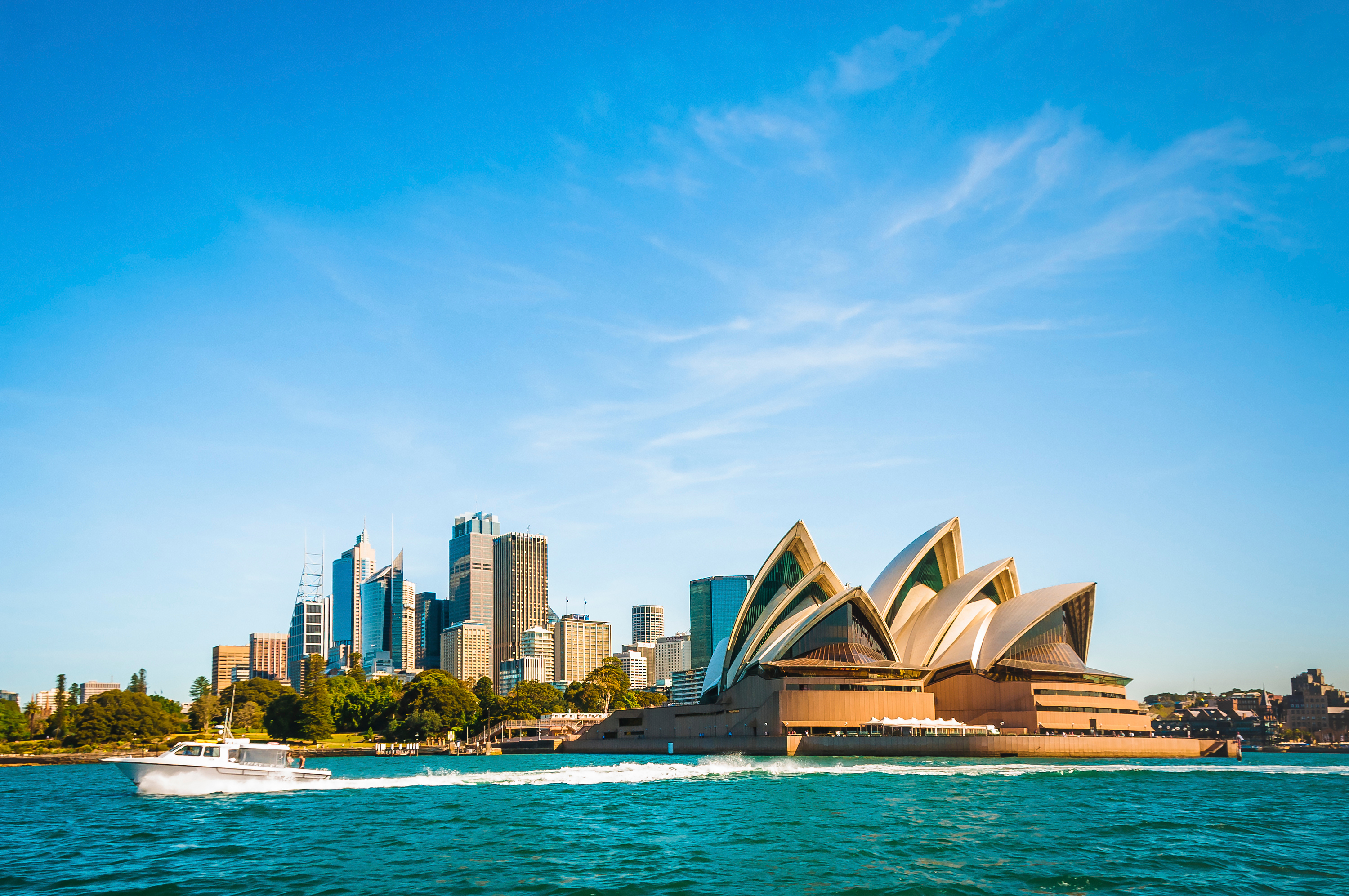 Sydney havn med verdensberømte Opera House og speedbåd under australsk sommerhimmel