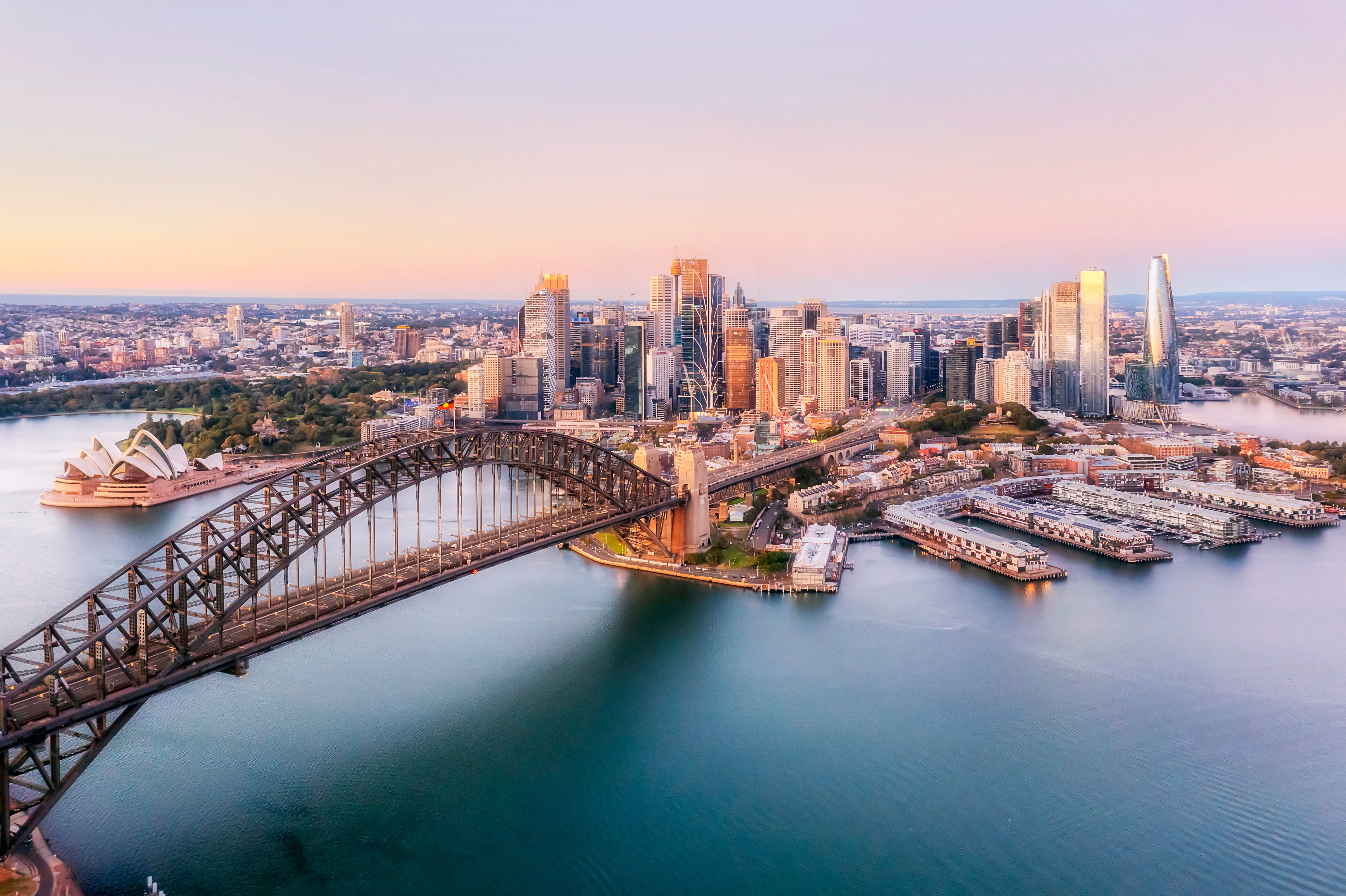 Sydney Opera House og havnebroen i smukt morgenlys med skyline