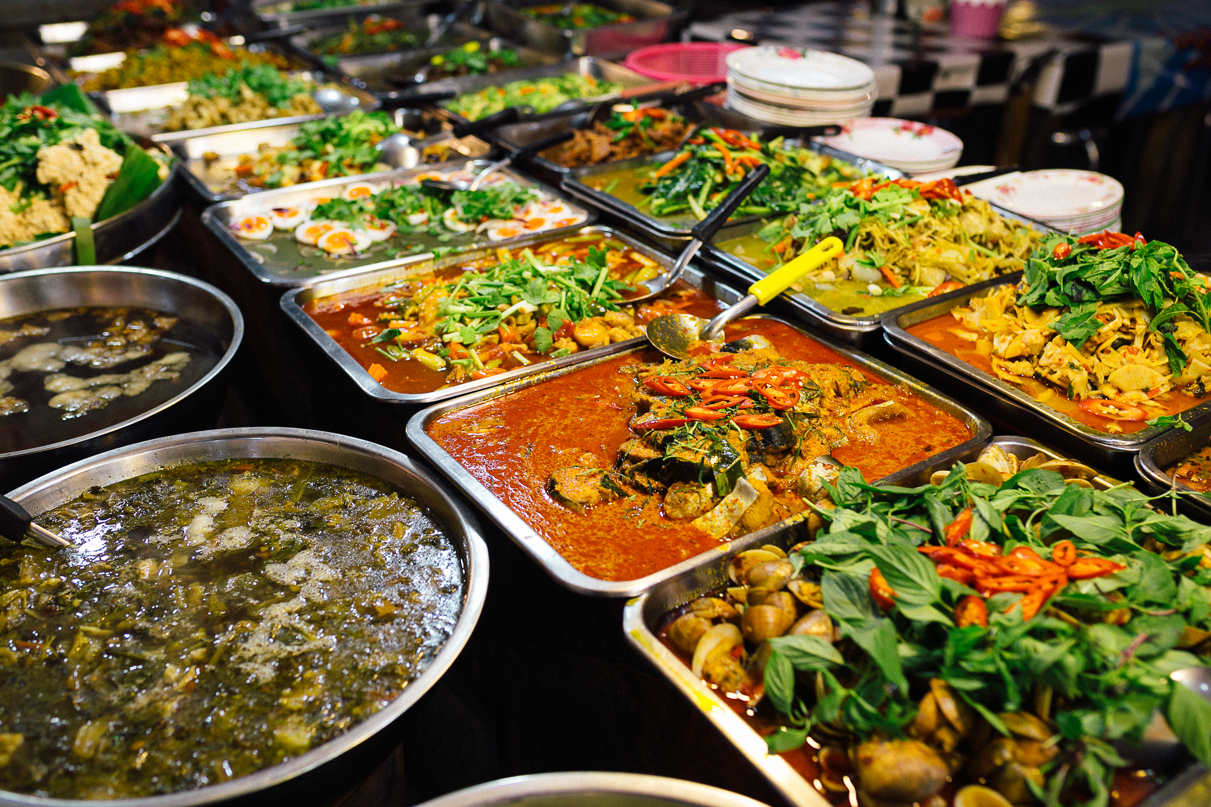 Sydøstasiatisk madkultur med traditionelle curry-retter og friske krydderier på autentisk marked