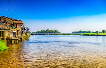 Pittoreske stilthuse ved Ping-floden i Tak-provinsen, Thailand, med spejlblankt vand og tropisk landskab