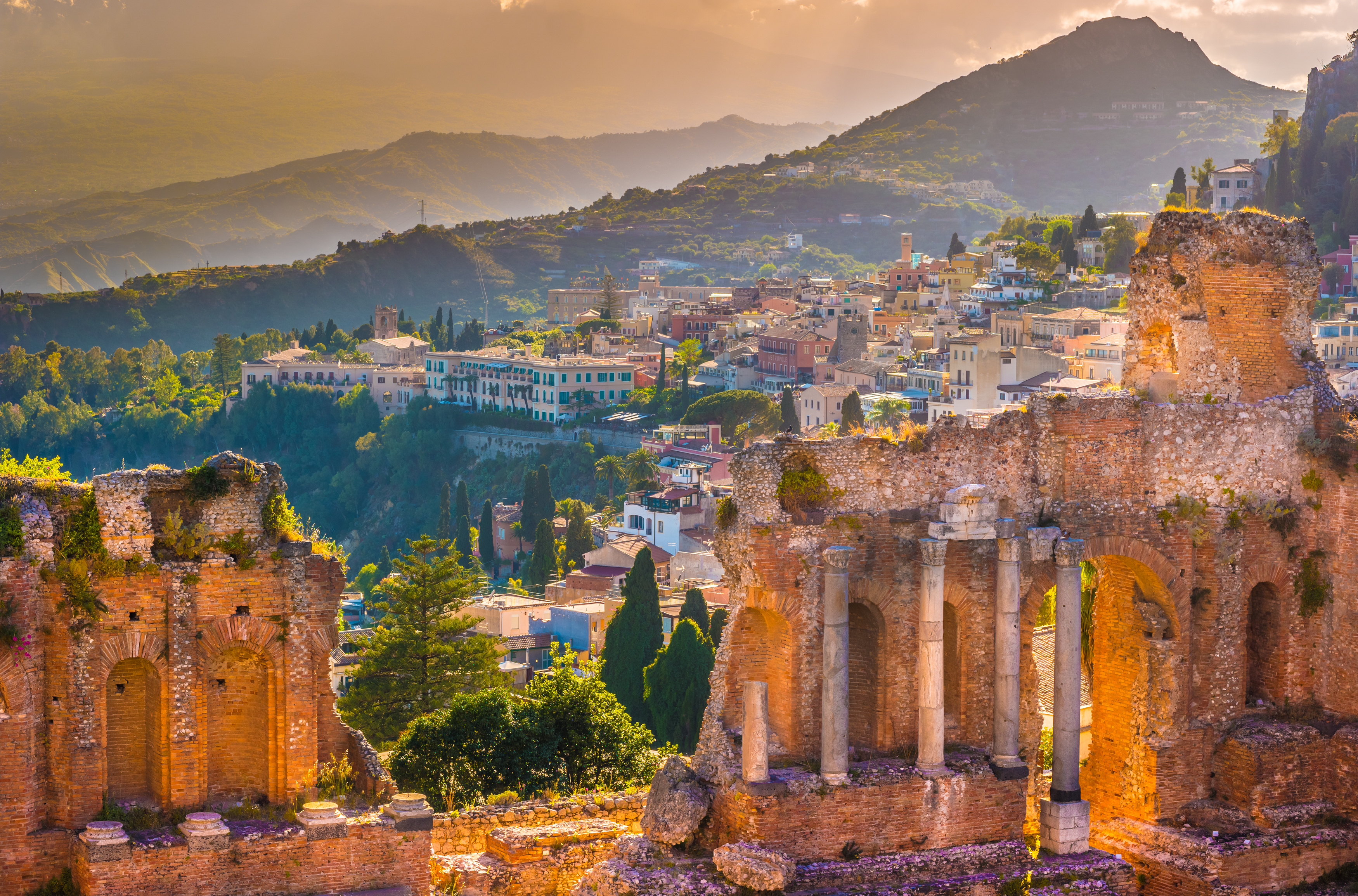 Fascinerende udsigt fra det antikke teater i Taormina på Sicilien med Middelhavet og Etna-vulkanen i baggrunden