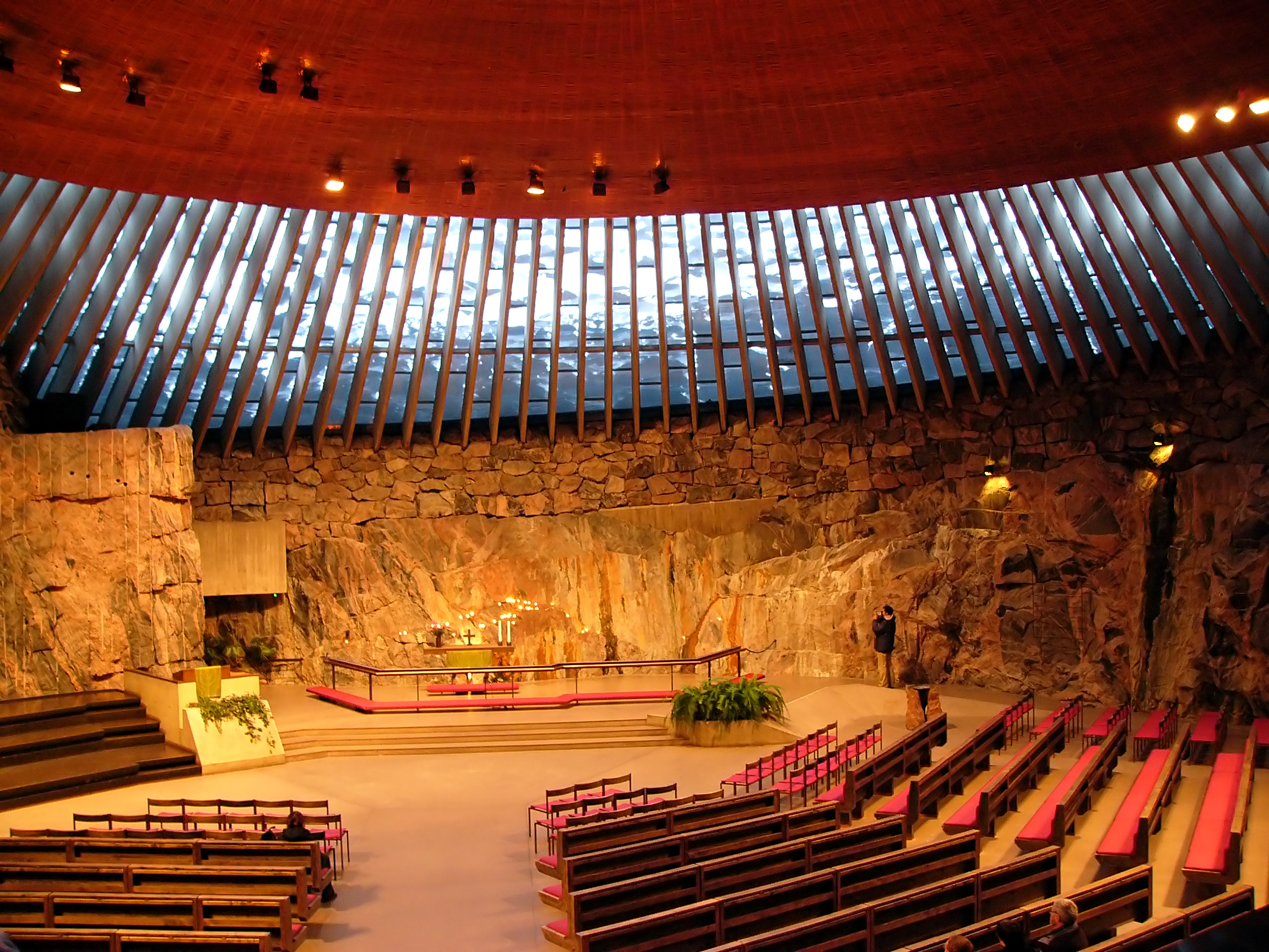 Stemningsfuldt interiør i den verdensberømte Temppeliaukio-kirke (Klippekirken) i Helsinki med dens dramatiske klippevægge og cirkulære kuppel - en af Finlands mest besøgte og arkitektonisk bemærkelsesværdige bygninger