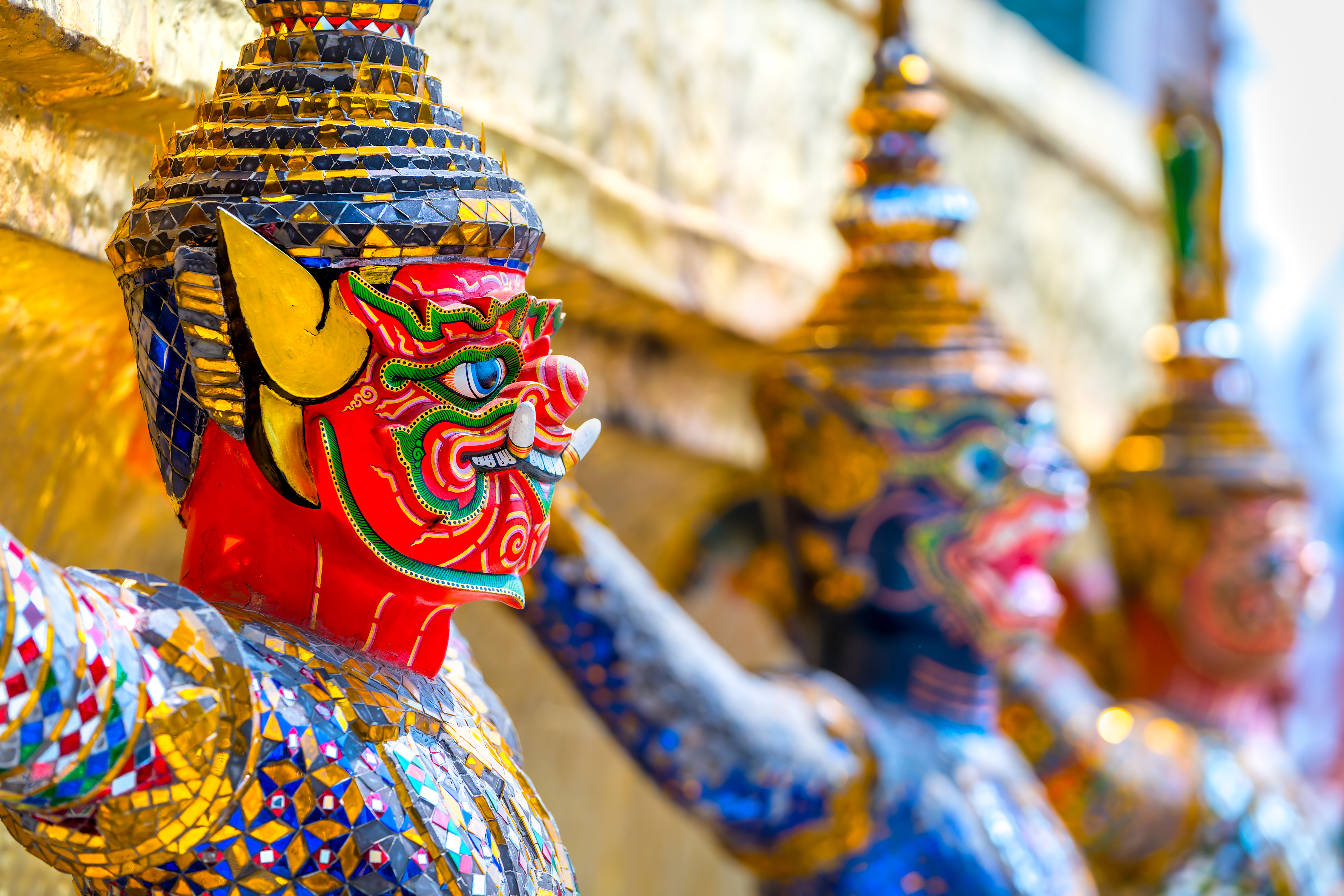 Farverige tempelvogtere med kompleks mosaik dekoration i thailandsk buddhist tempel