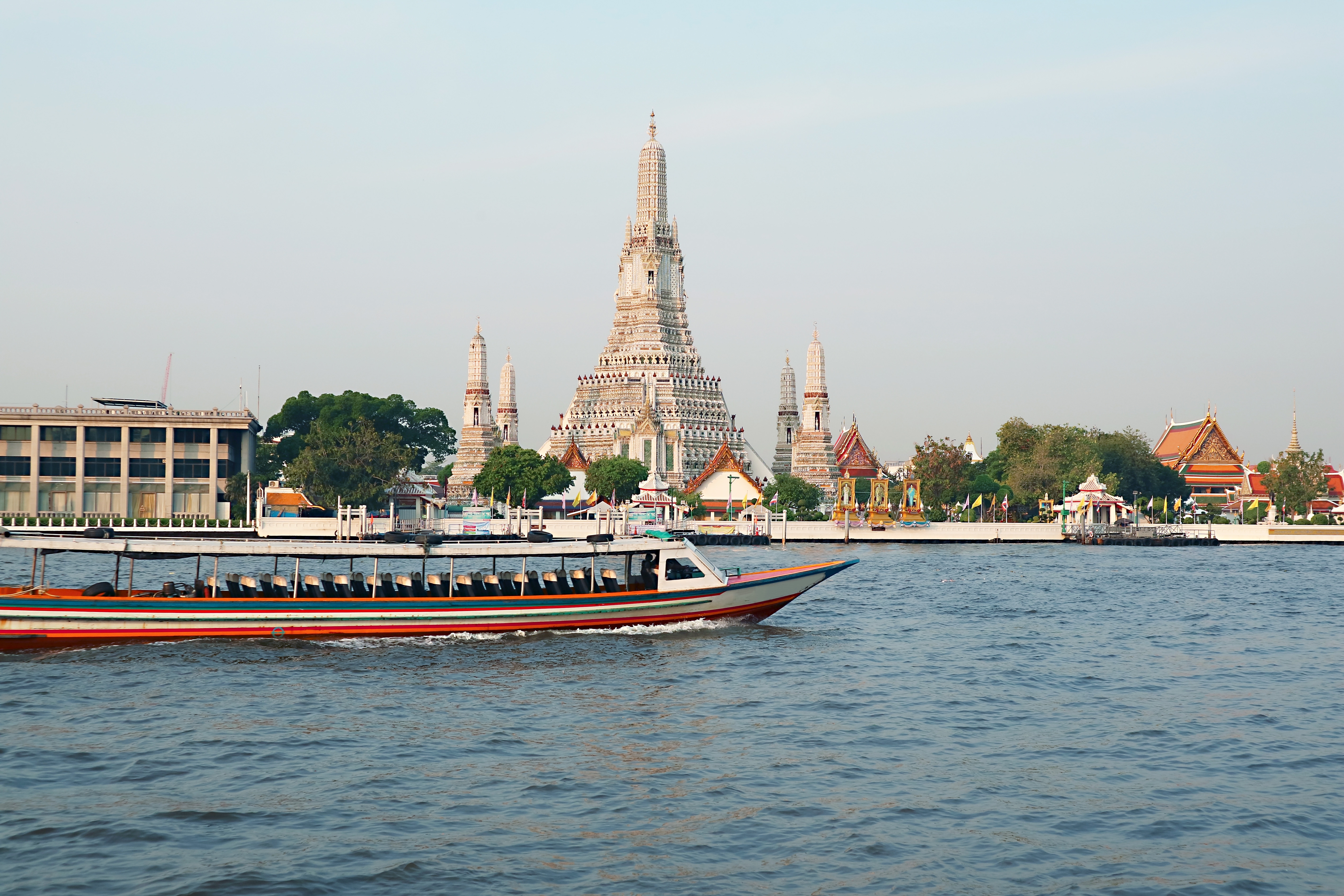 Traditionel thailandsk riverboat foran det historiske Wat Arun tempel i Bangkok