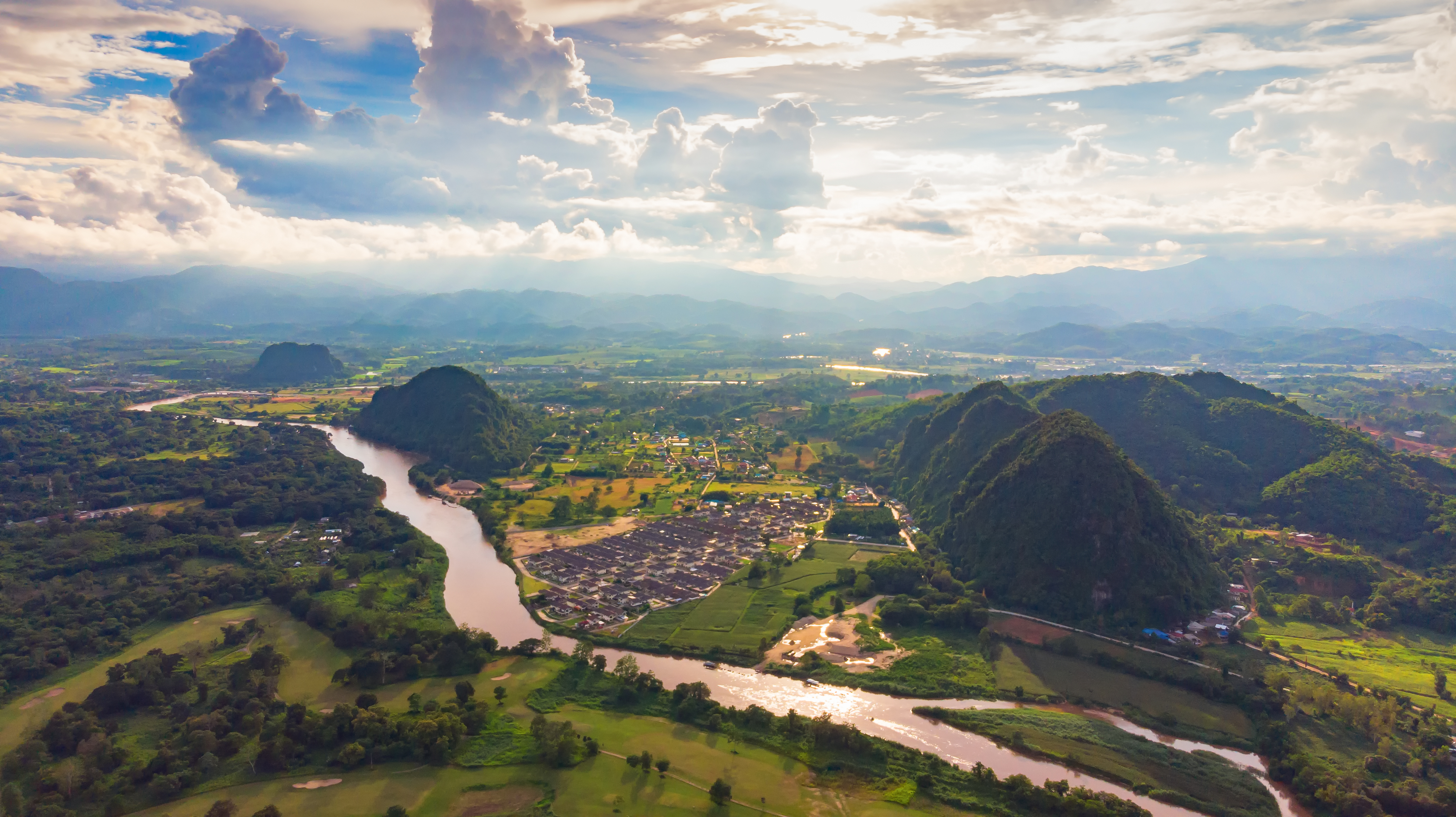 Naturskønt landskab med flod der slynger sig gennem bjergdal i Thailand