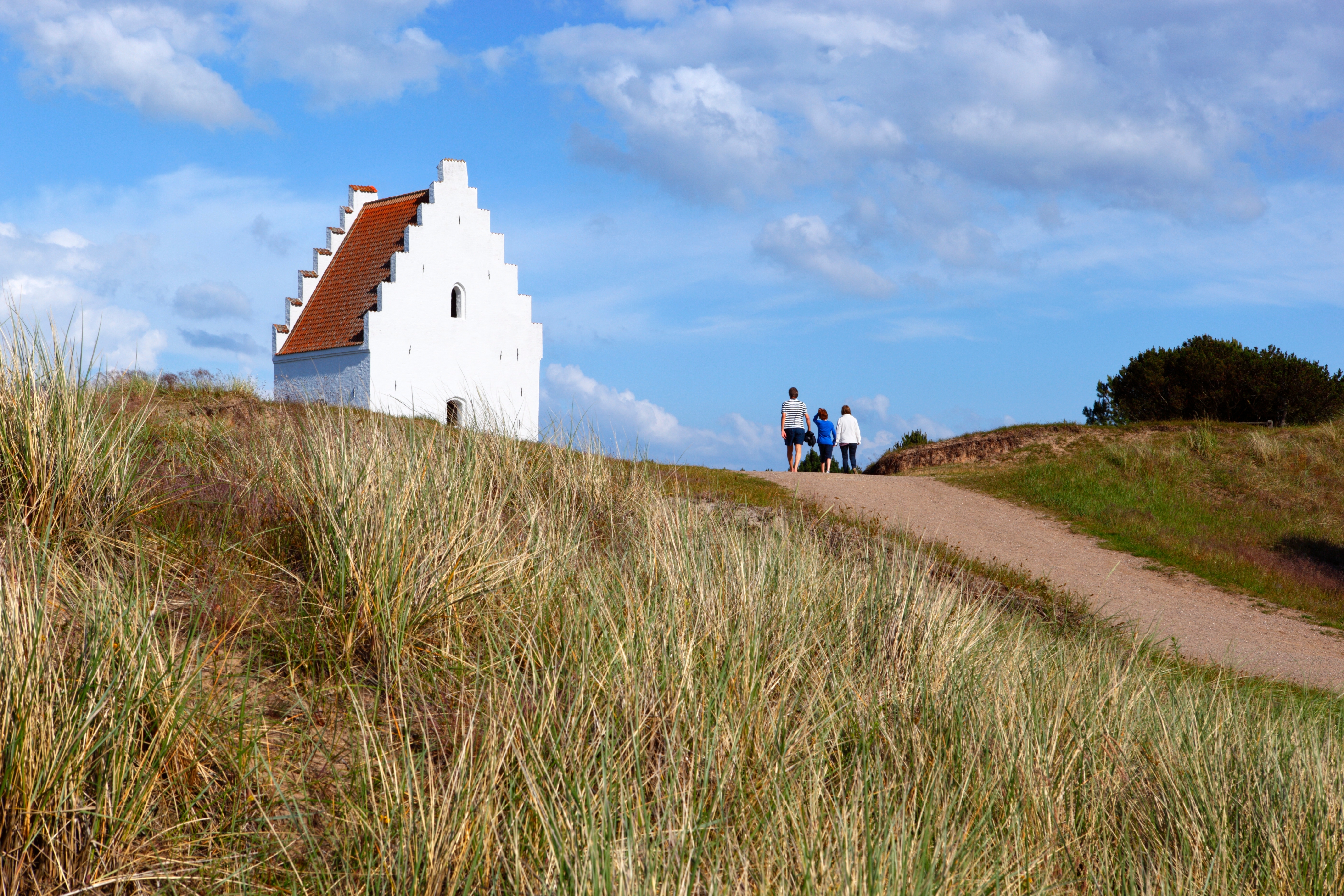 Besøgende på sandsti ved Den Tilsandede Kirke i Skagen, Jylland – et unikt dansk kulturminde midt i klitlandskabet