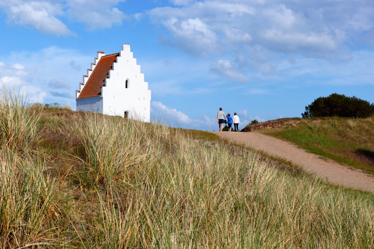 Besøgende på sandsti ved Den Tilsandede Kirke i Skagen, Jylland – et unikt dansk kulturminde midt i klitlandskabet