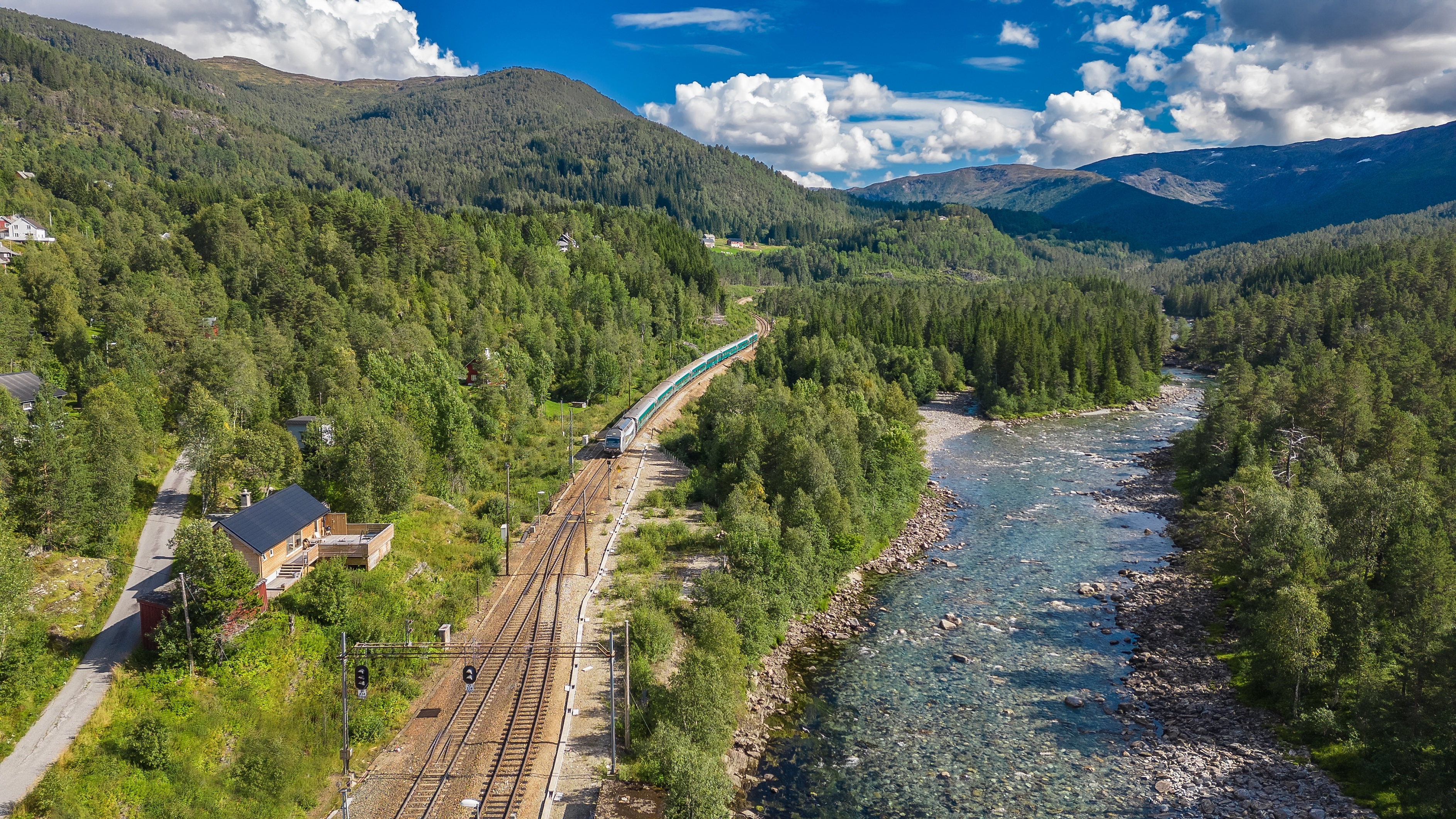 Et passagertog på den berømte Bergensbane skærer gennem det storslåede norske fjeldlandskab nær Mjolfjell på rejsen mellem Oslo og Bergen