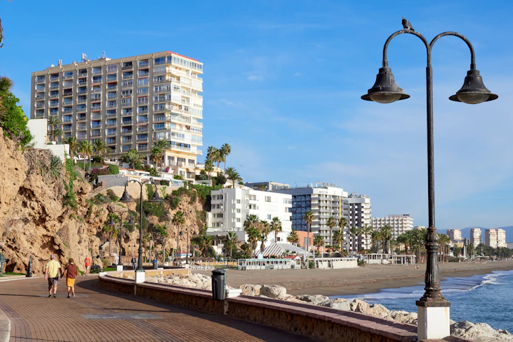 Dejlig kystpromenade langs Carihuela stranden i Torremolinos med palmer og hotelkomplekser ved Middelhavet