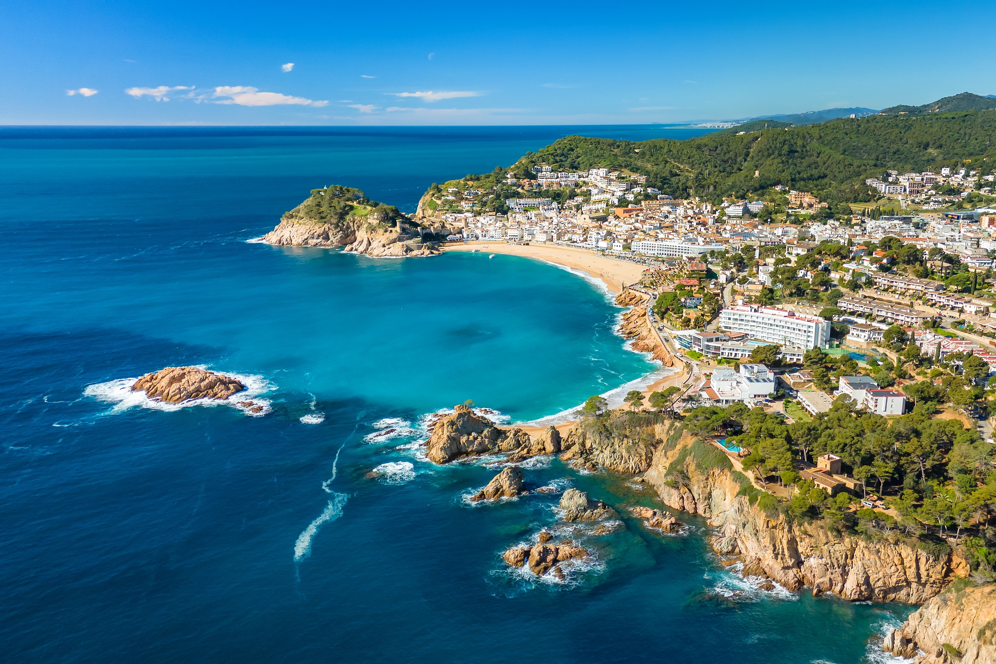 Fantastisk udsigt over Tossa de Mar på Spaniens Costa Brava med turkist Middelhav, idyllisk sandstrand og hvid kystby omgivet af grønt