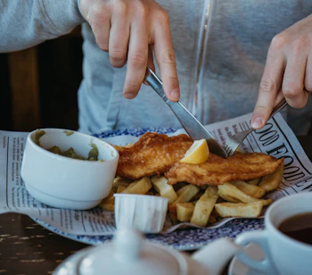 Traditionel britisk fish and chips serveret med pommes frites i skotsk restaurant