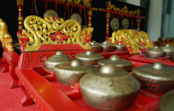 Traditionelt gamelan-orkester med gyldne drage-udskæringer og bronzegonger på Java, Indonesien