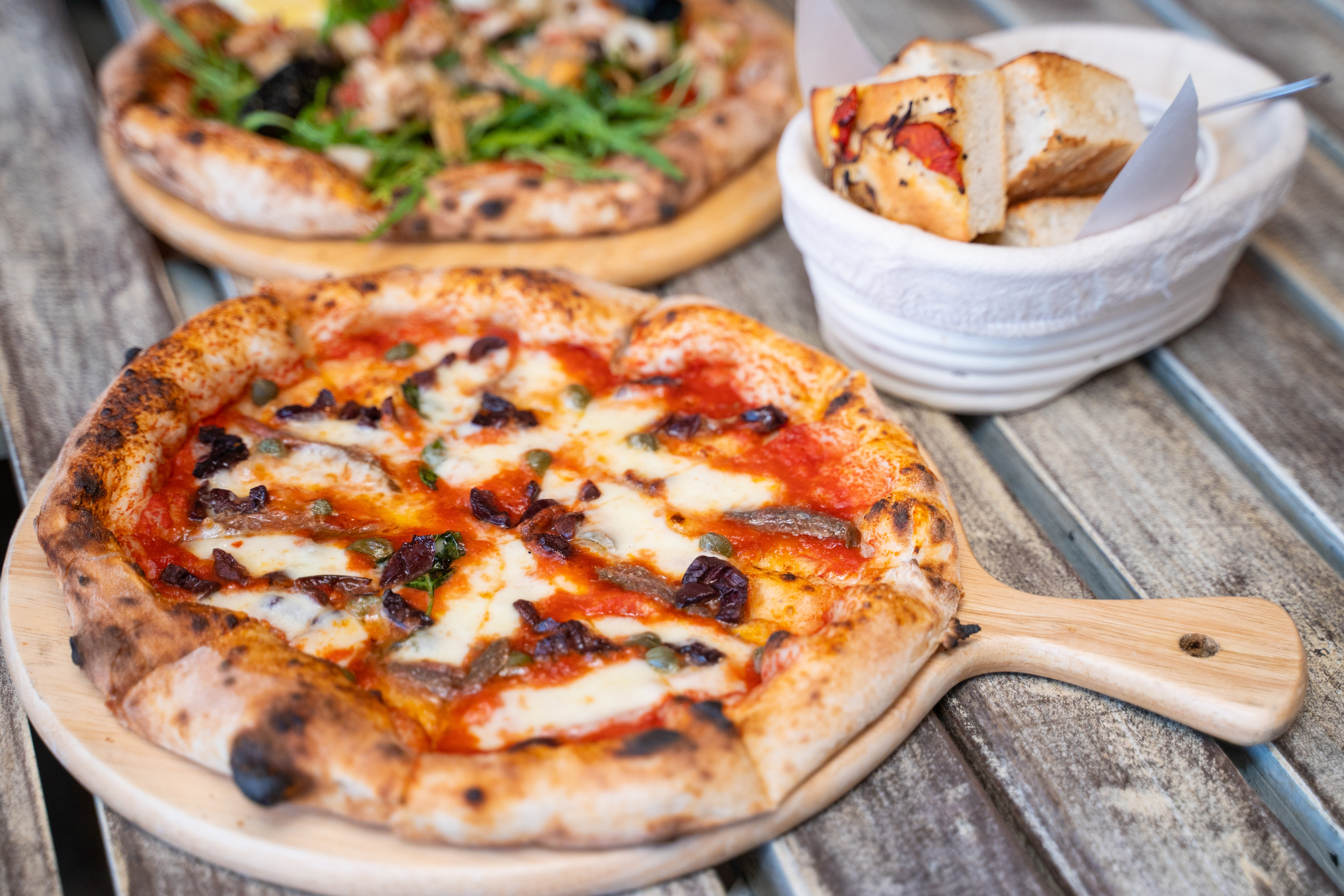 Traditionel italiensk pizza med havfrugter serveret på træbræt