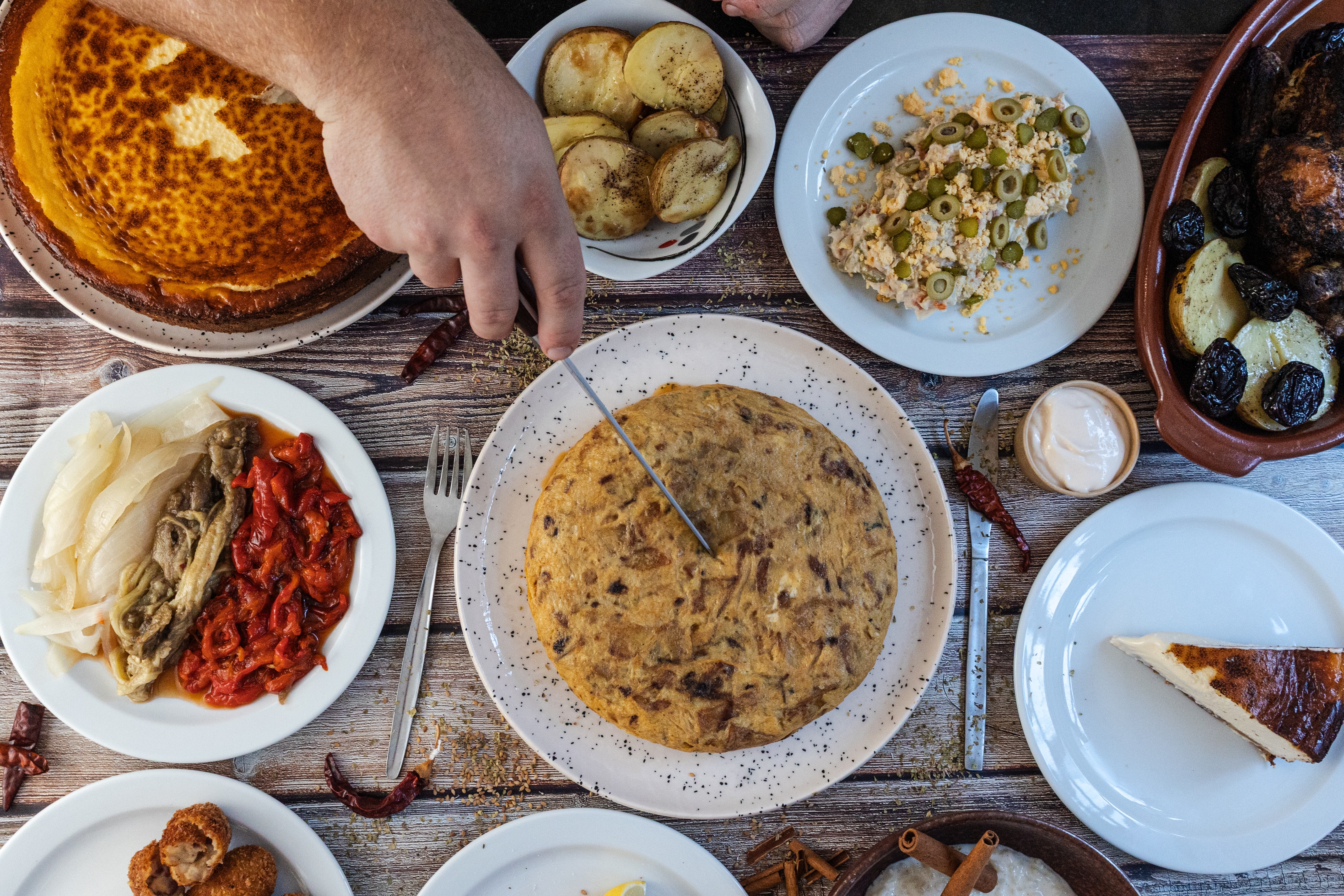 Traditionelt spansk tapas-bord set fra oven med tortilla española, oliven, ristede pebre og hjemmelavede mediterrane retter til en autentisk frokostoplevelse