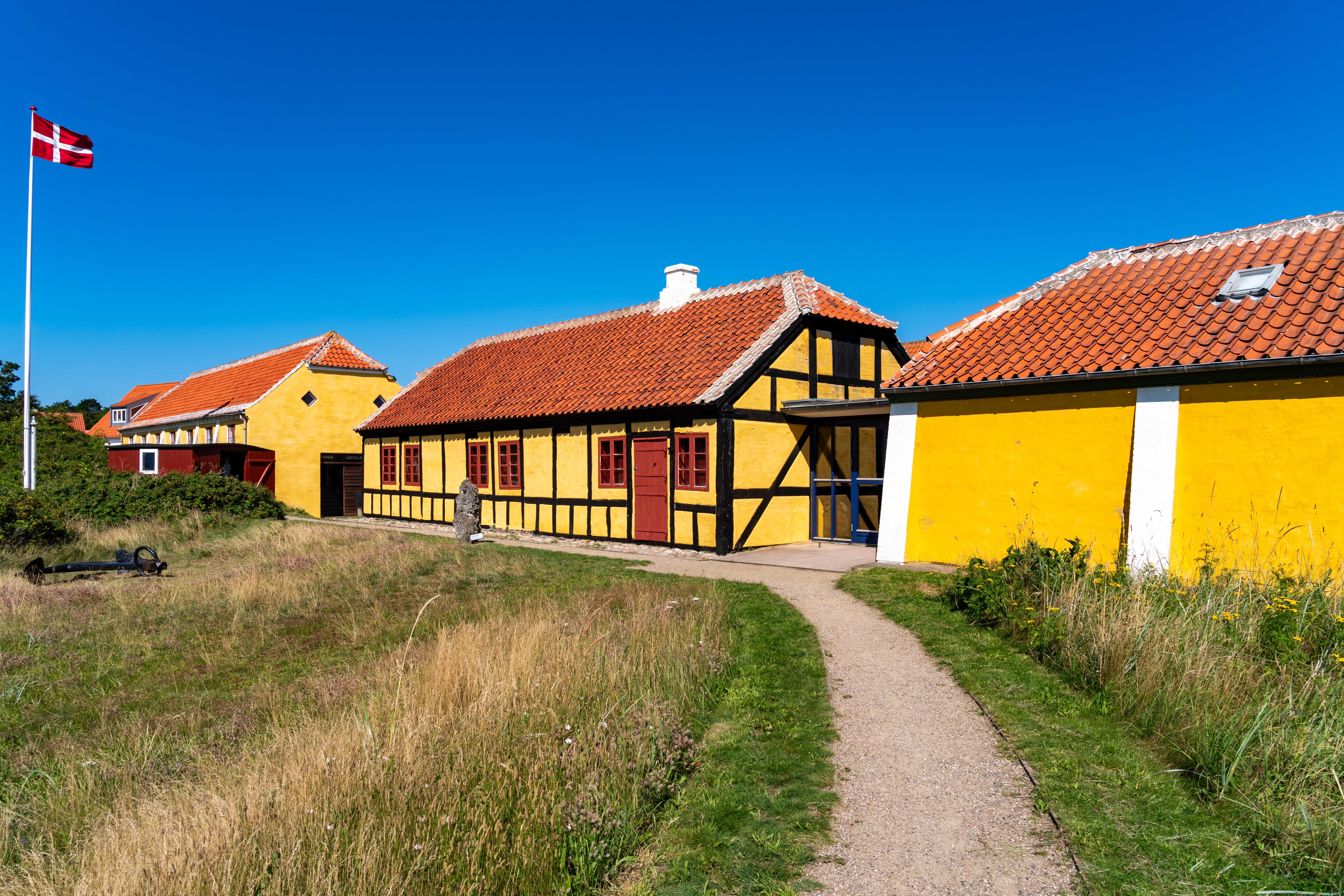 Idylliske traditionelle gule huse med røde tegltage og stisystem i Skagen på Danmarks nordspids