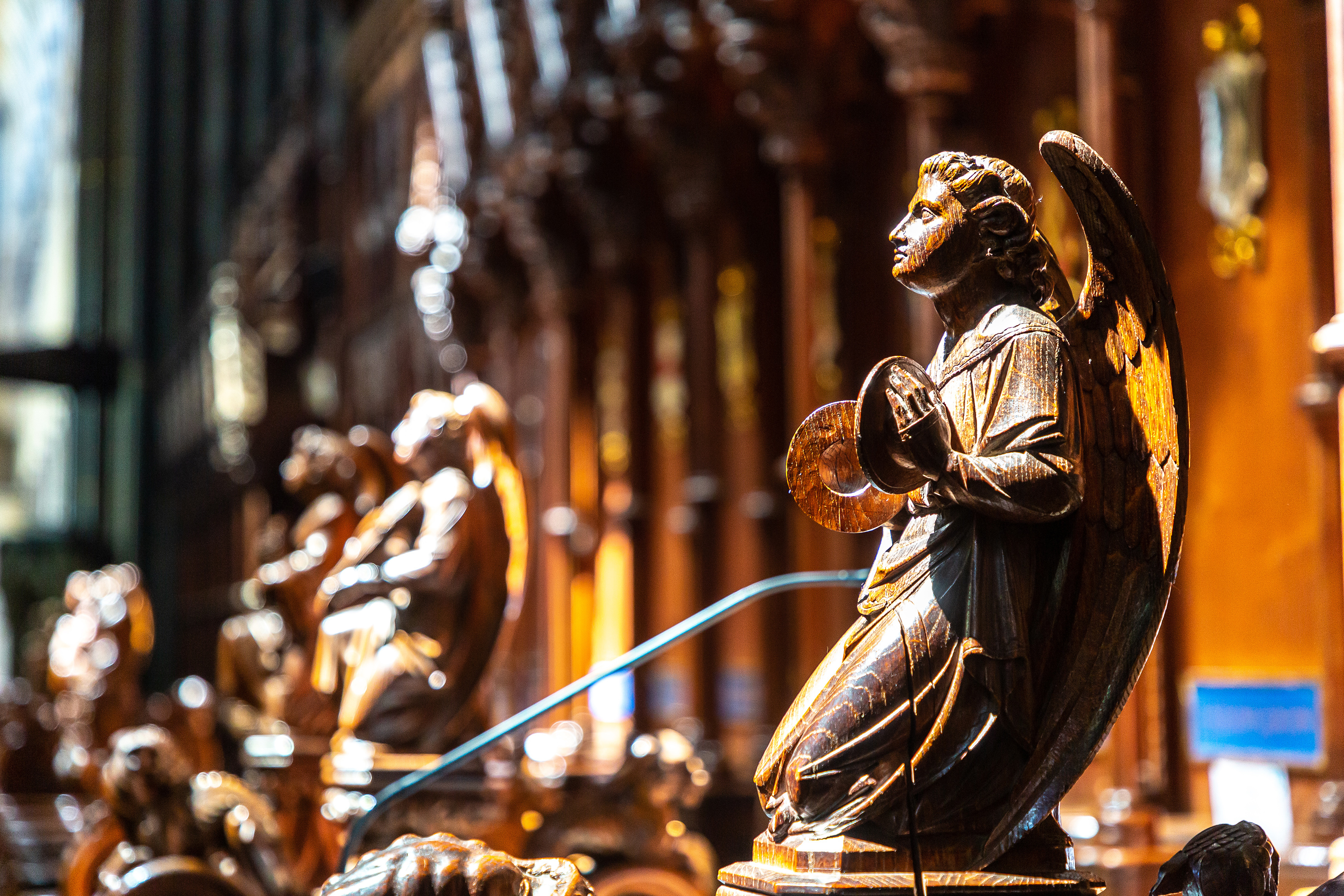 Pragtfuld udskåret træengel i bøn ved korstolene i Salisbury Cathedral, England