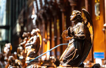 Pragtfuld udskåret træengel i bøn ved korstolene i Salisbury Cathedral, England