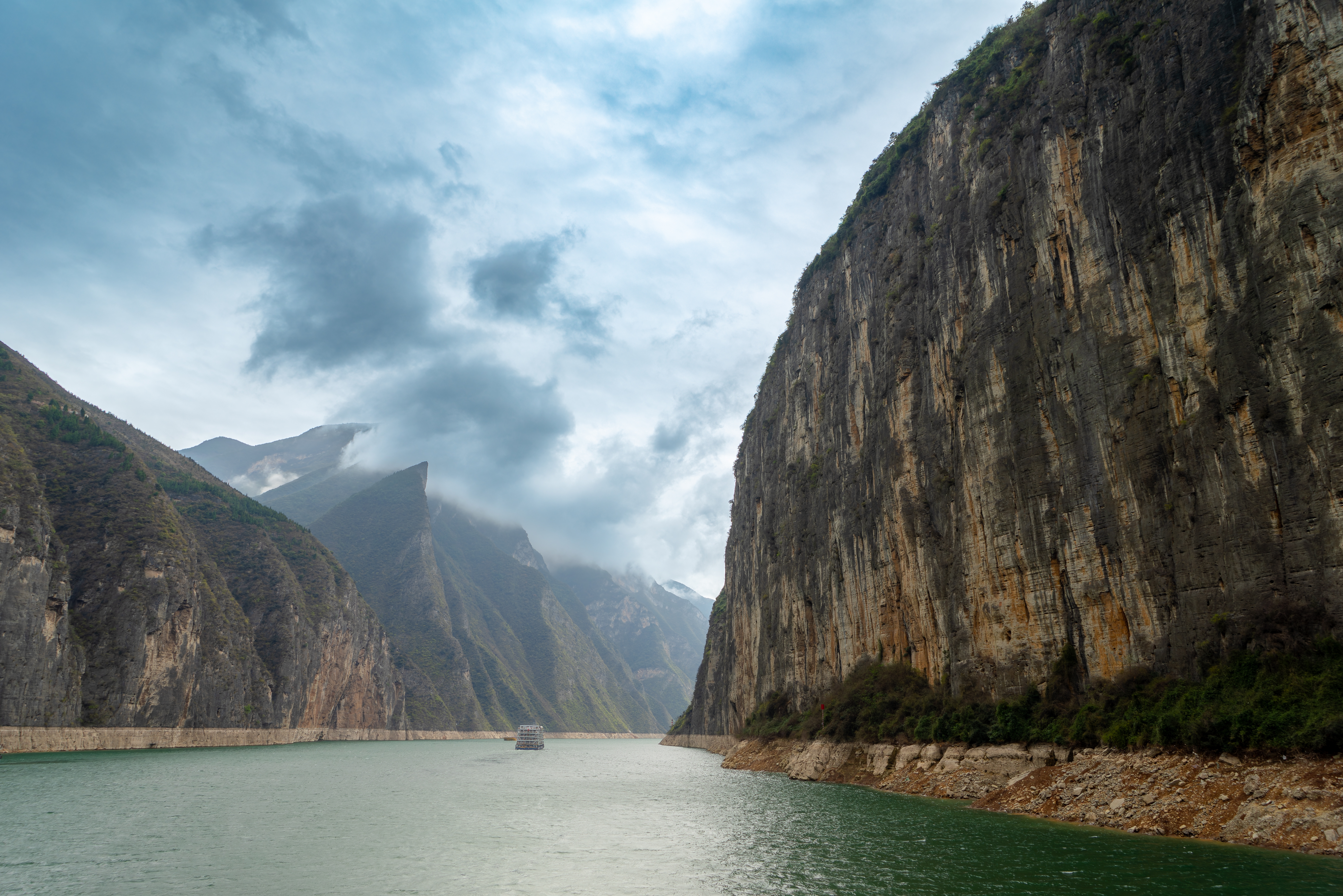 Smukt udsyn over De Tre Kløfter langs Yangtze-floden i Kina med dramatiske klipper og fredfyldt grønt flodvand