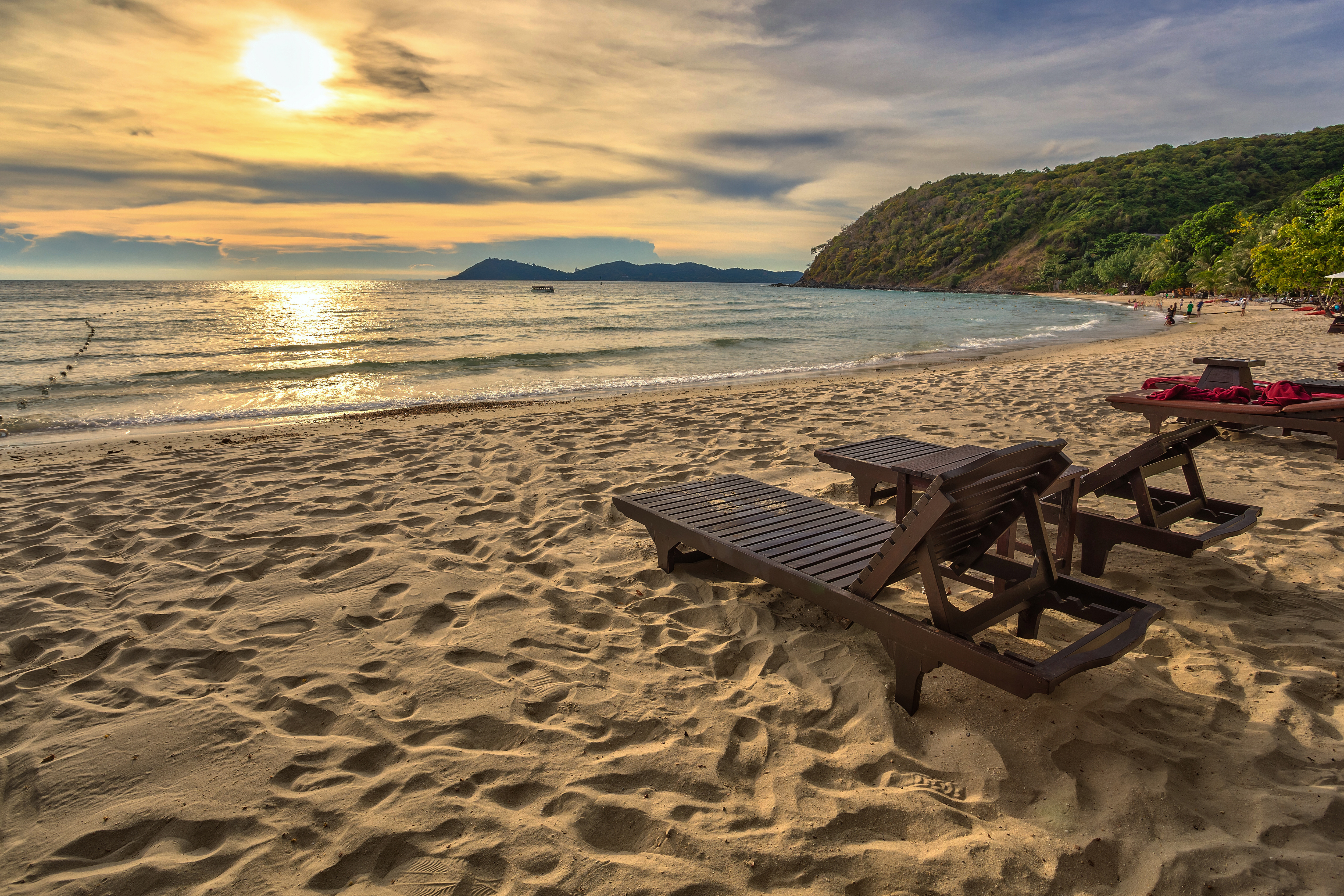 Tropisk paradis strand med solnedgang og liggestole i Thailand