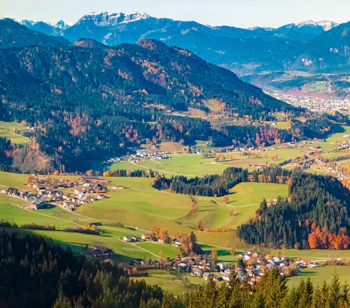 Naturskønt efterårspanorama over den alpine Itter-dal med grønne enge og farverige skove ved Kitzbühel i Tyrol, Østrig