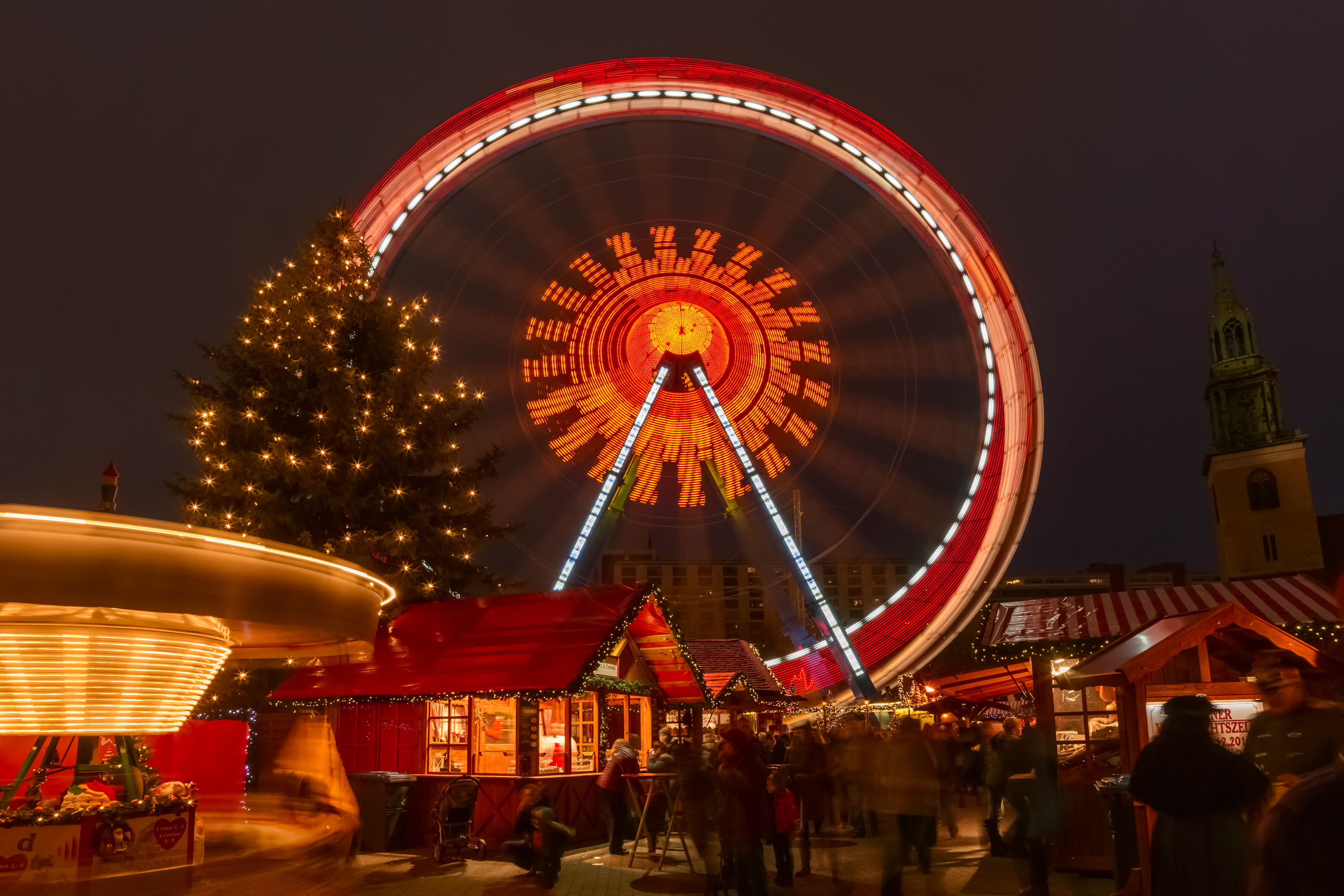 Hyggelig tysk julemarked med stort pariserhjul og festlig julestemning om aftenen