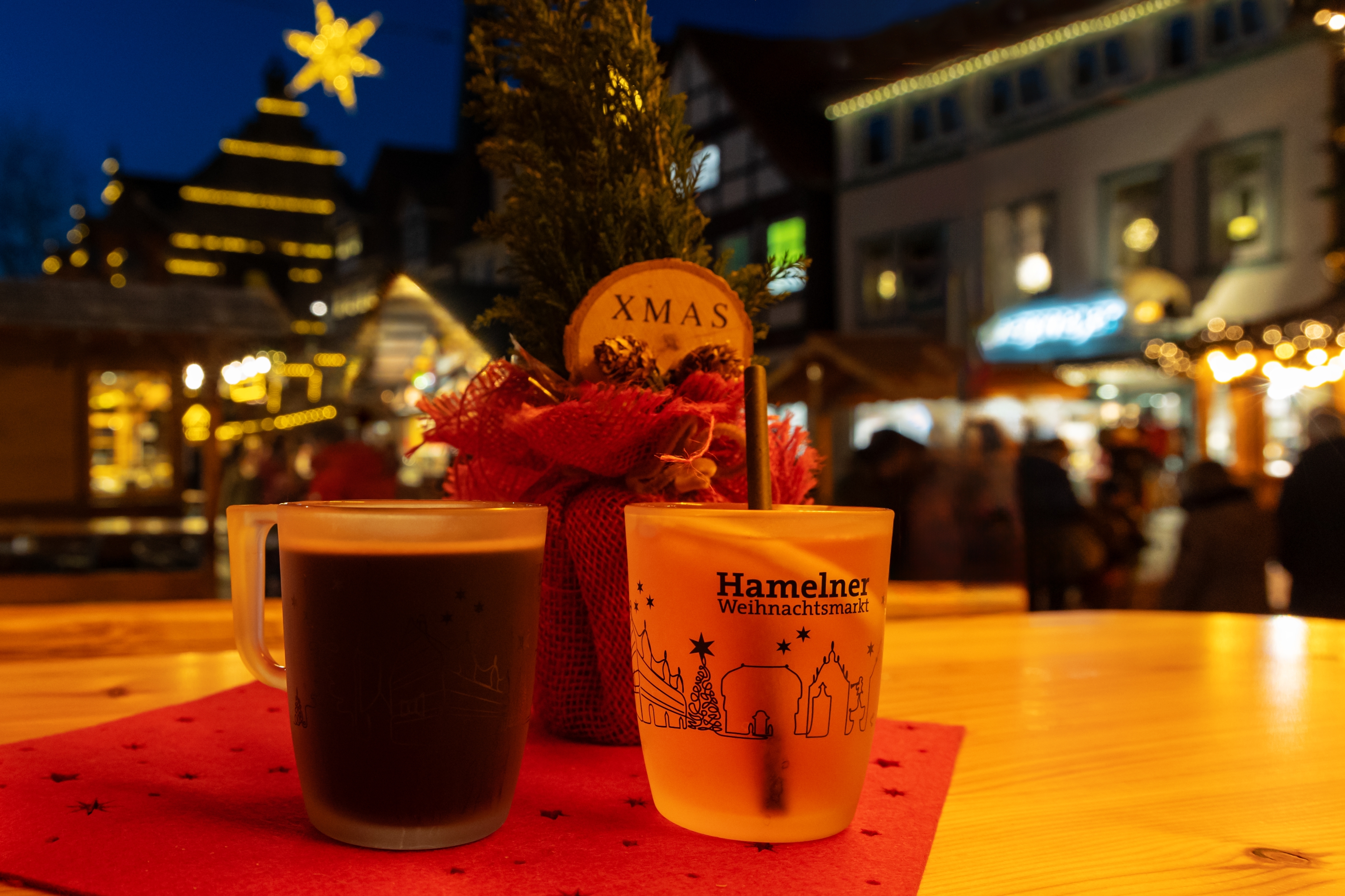 Traditionelle glöggkrus på det festlige julemarked i Hameln med flotte lys og magisk aftenstemning