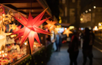 Festlig rød stjernedekoration på traditionelt tysk julemarked med varmt lys og julehygge