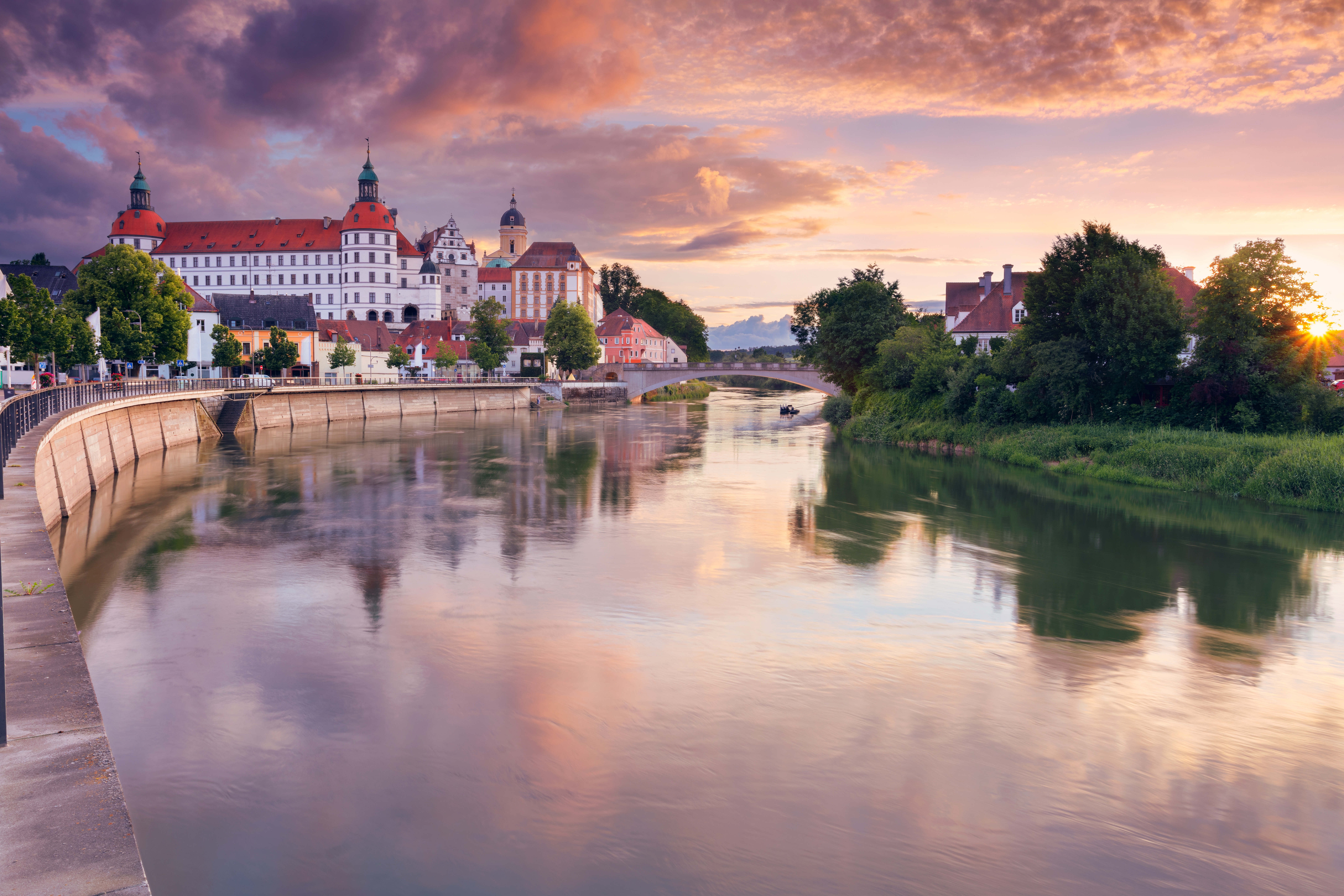 Smukt slot og barokkirke ved Donau-floden i aftensol, Neuburg, Tyskland